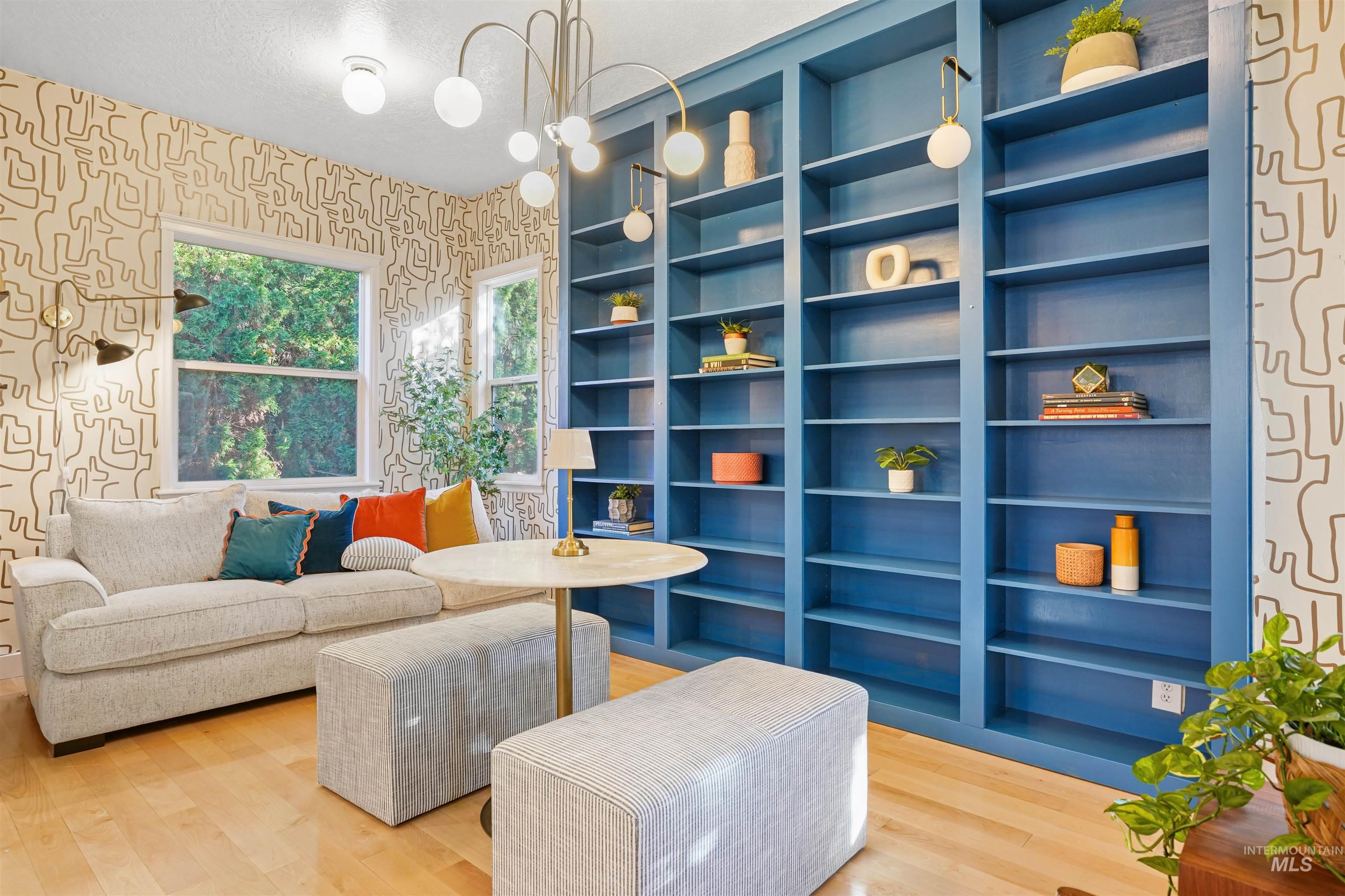 Sitting room featuring wallpapered walls, wood finished floors, and a textured ceiling