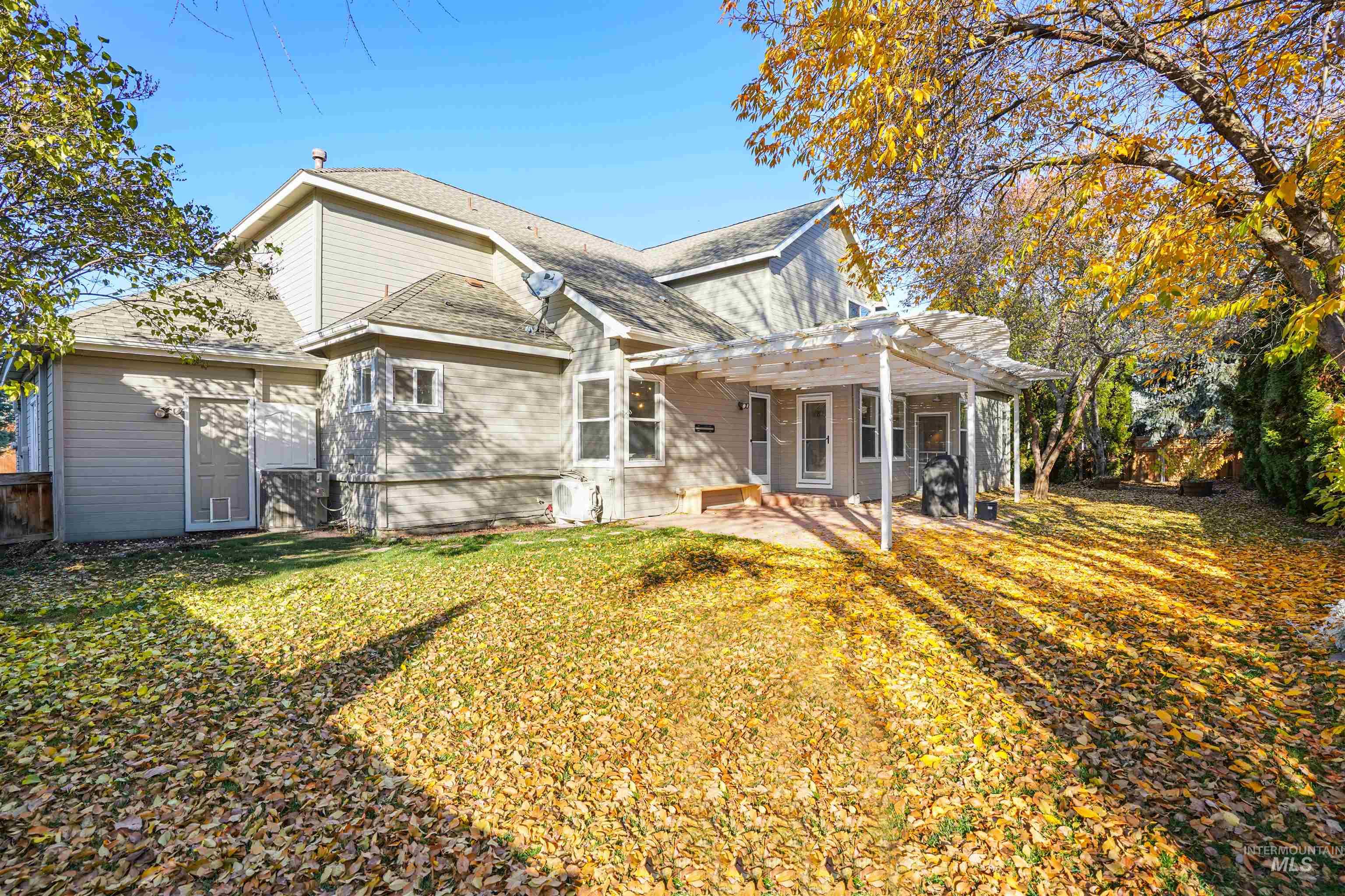 Back of house featuring a patio area, a lawn, and a shingled roof