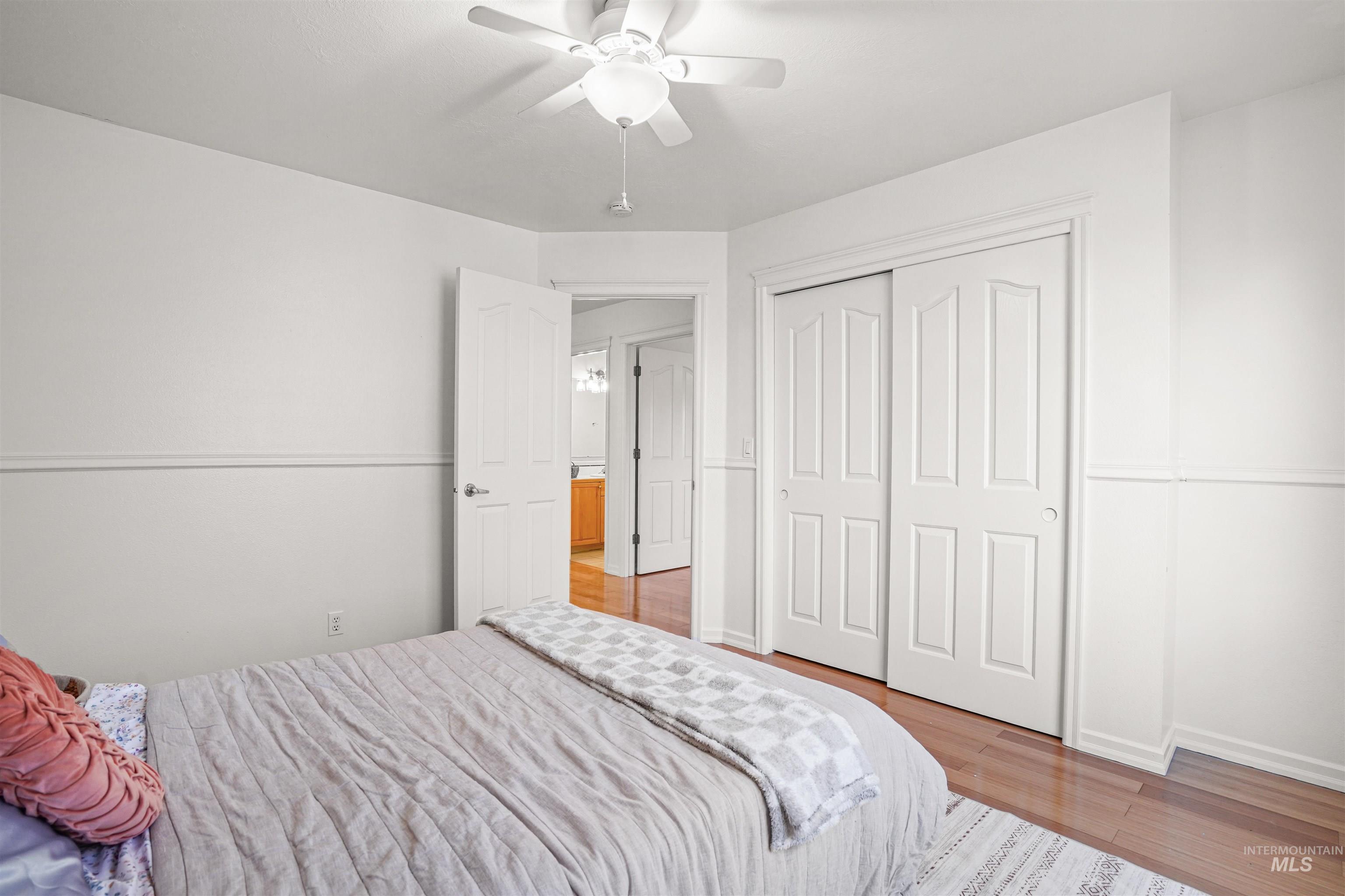 Bedroom featuring wood finished floors, a closet, and ceiling fan