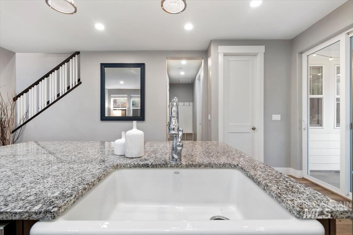 Kitchen view of recessed lighting and light stone countertops