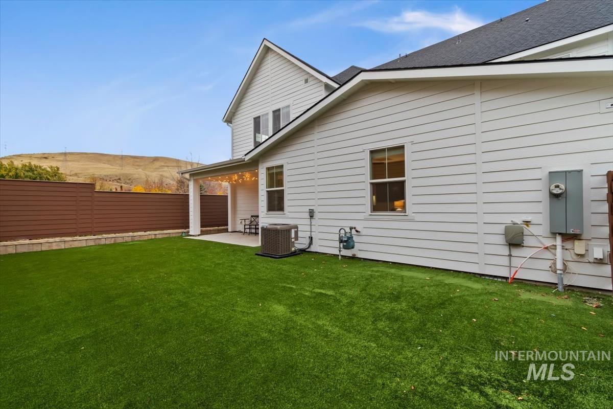 Back of house with a patio area and a shingled roof