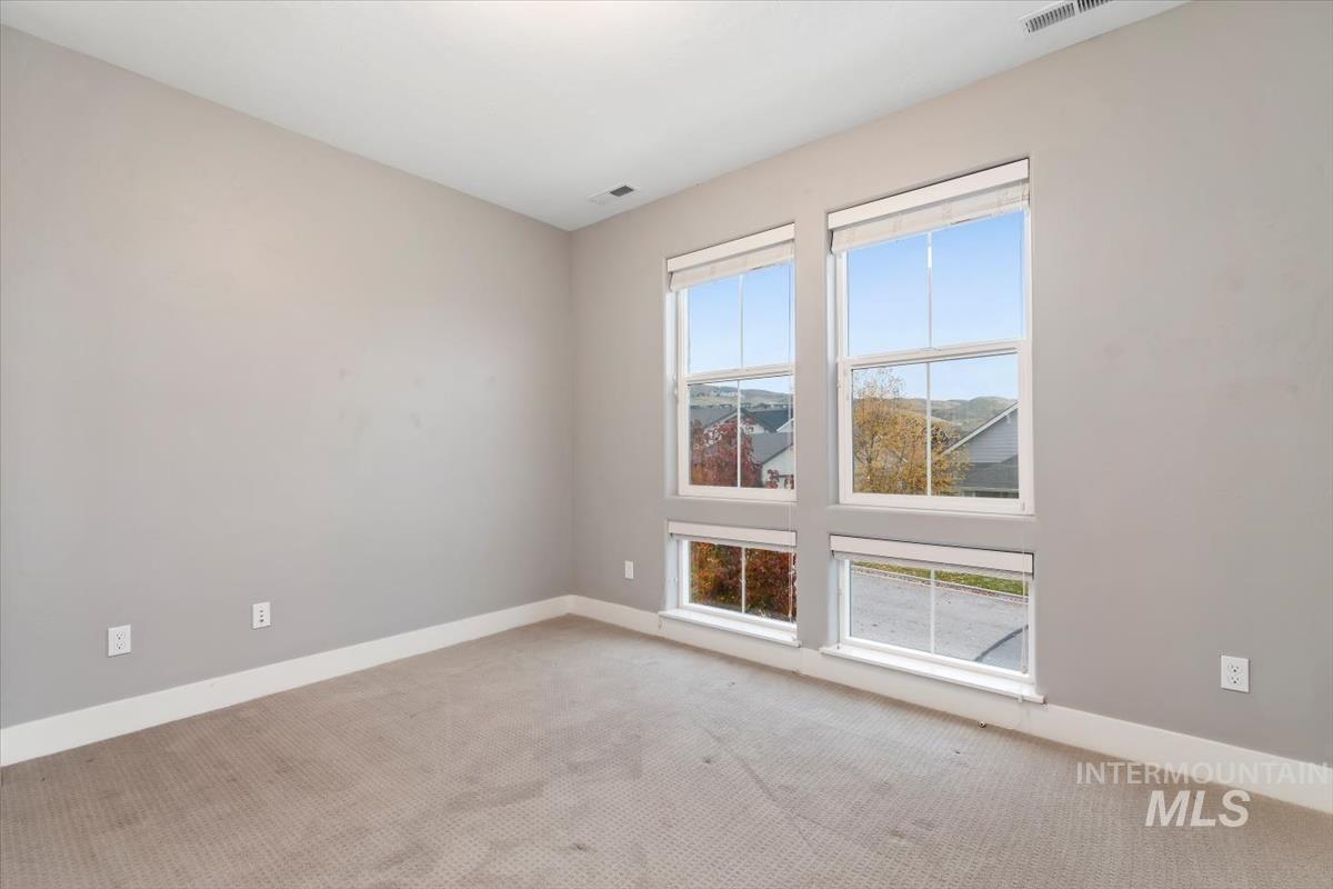 Carpeted empty room featuring baseboards