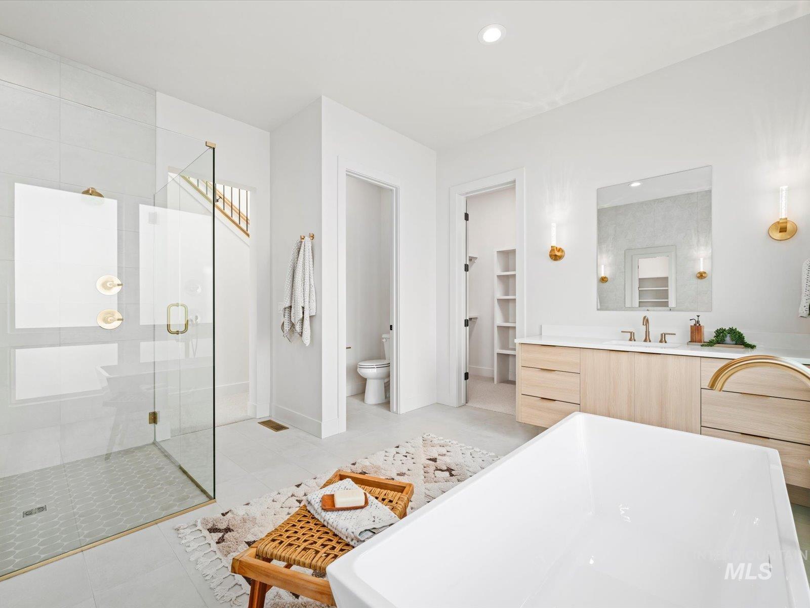 Bathroom featuring vanity, a shower stall, light tile patterned flooring, a spacious closet, and a freestanding tub