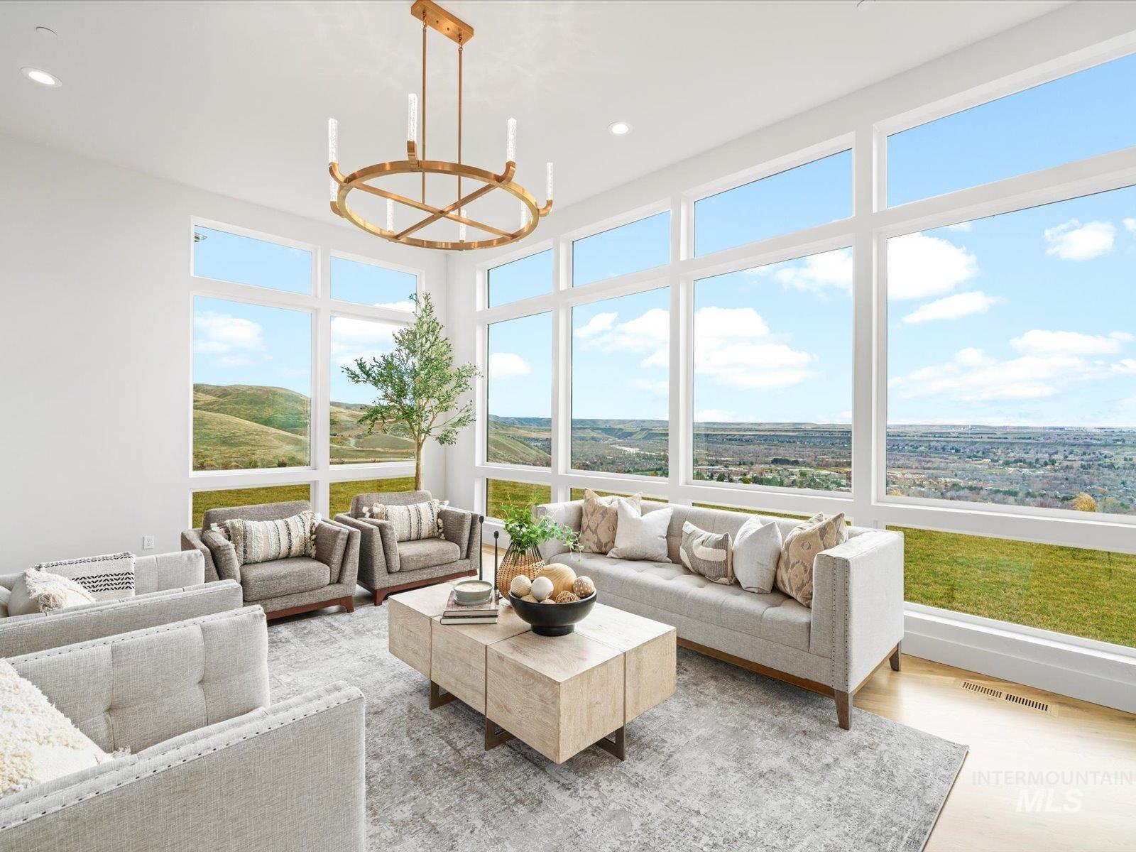 Sunroom with wood finished floors, a chandelier, and recessed lighting