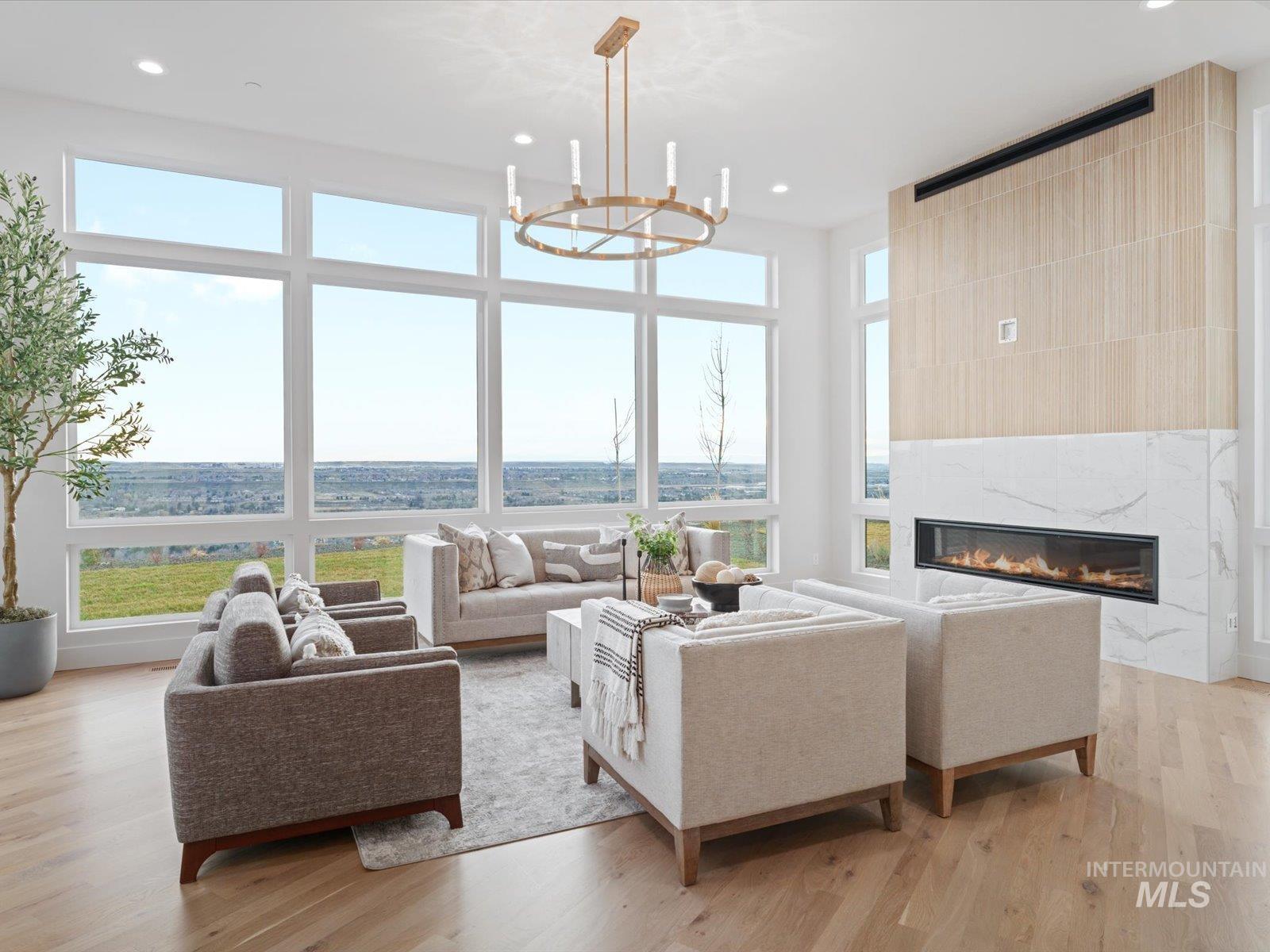Living area featuring a fireplace, light wood-style floors, plenty of natural light, and recessed lighting