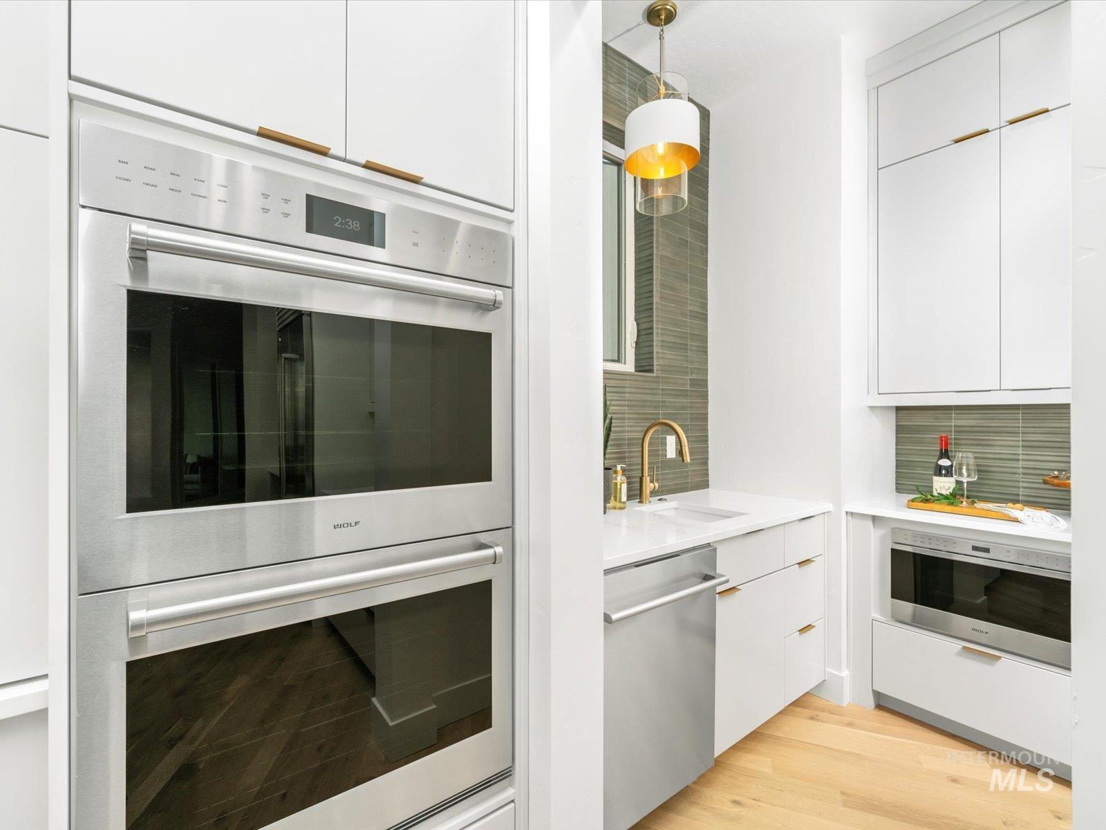 Kitchen with white cabinets, modern cabinets, and stainless steel appliances