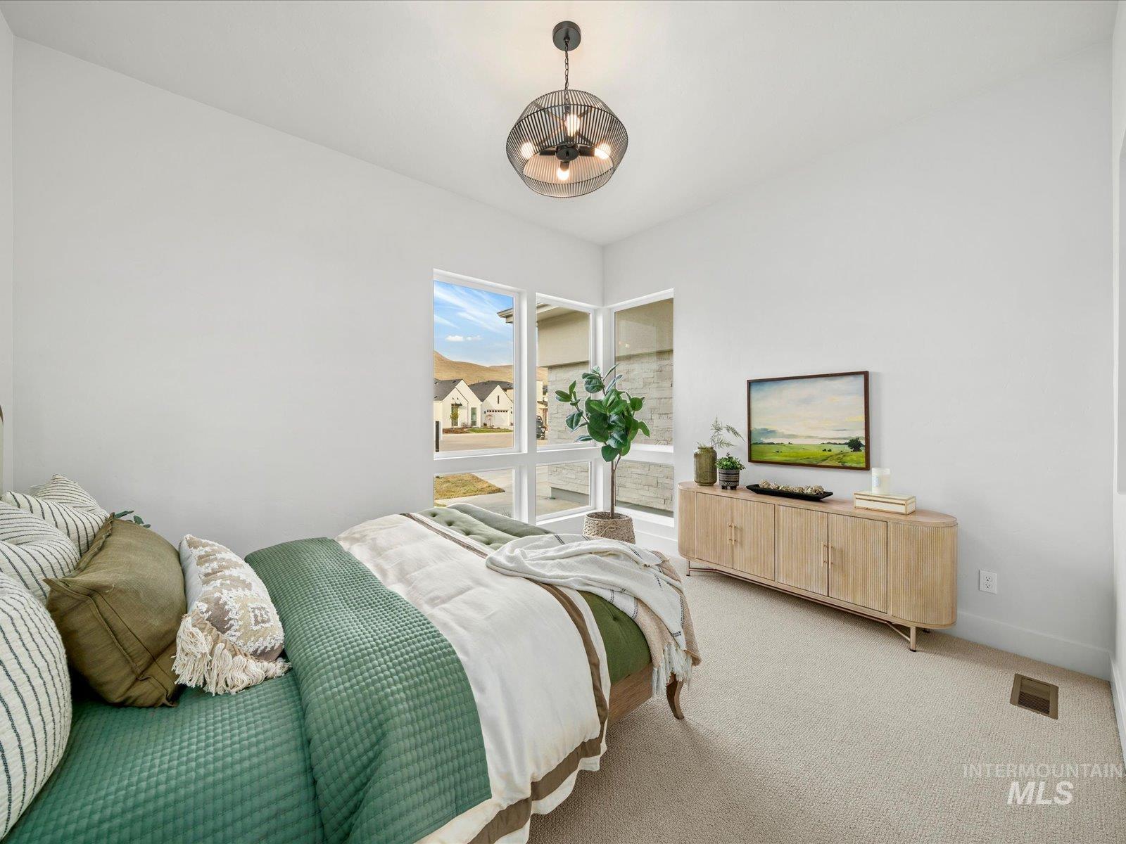 Carpeted bedroom with baseboards and a chandelier