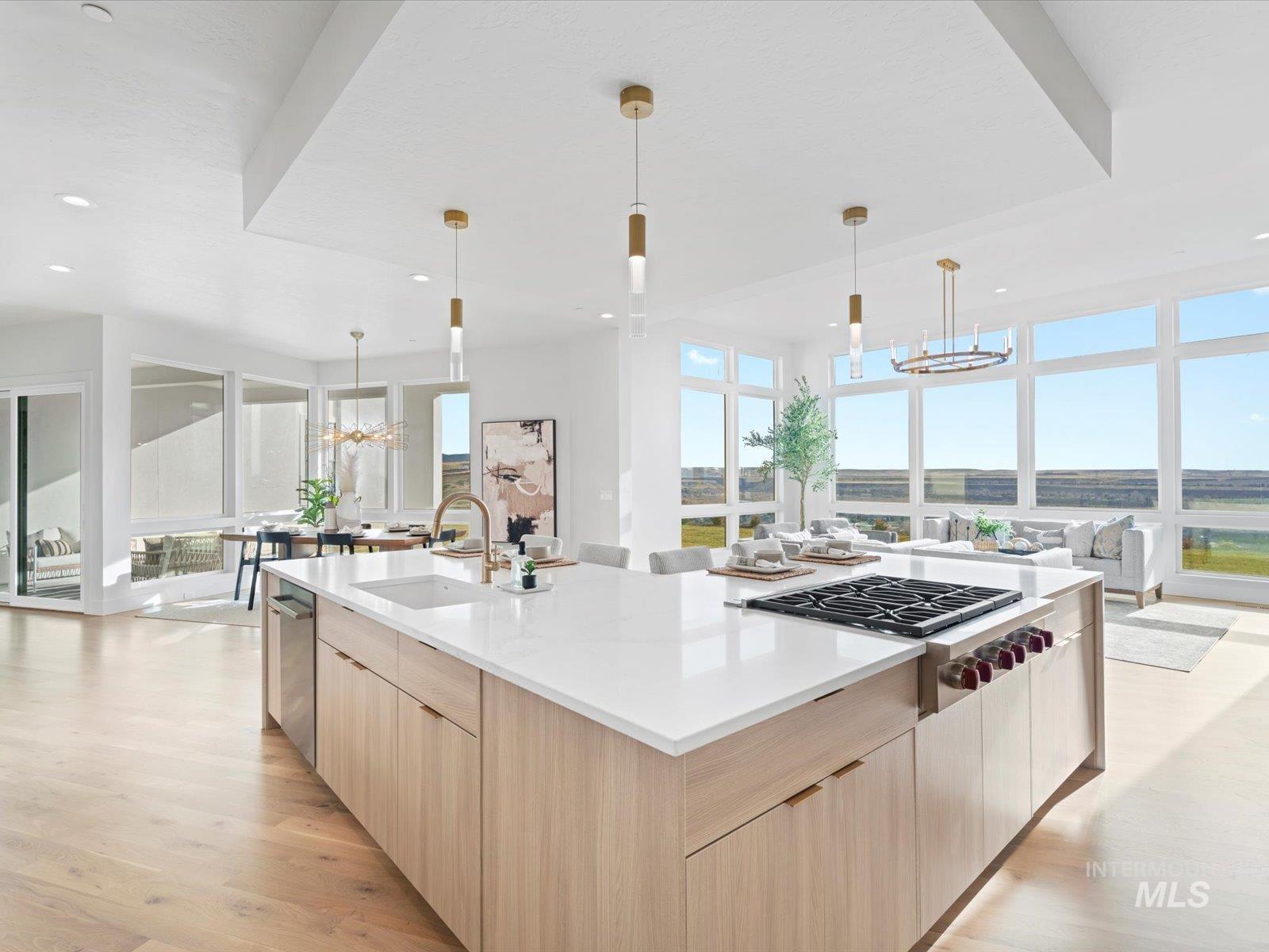 Kitchen with a chandelier, modern cabinets, light brown cabinets, hanging light fixtures, and light wood-type flooring