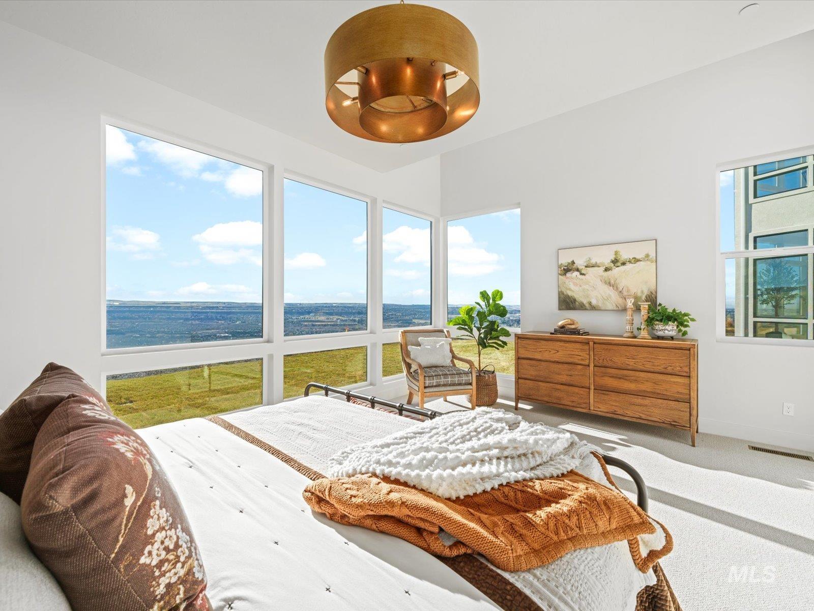 Carpeted bedroom with multiple windows and a water view