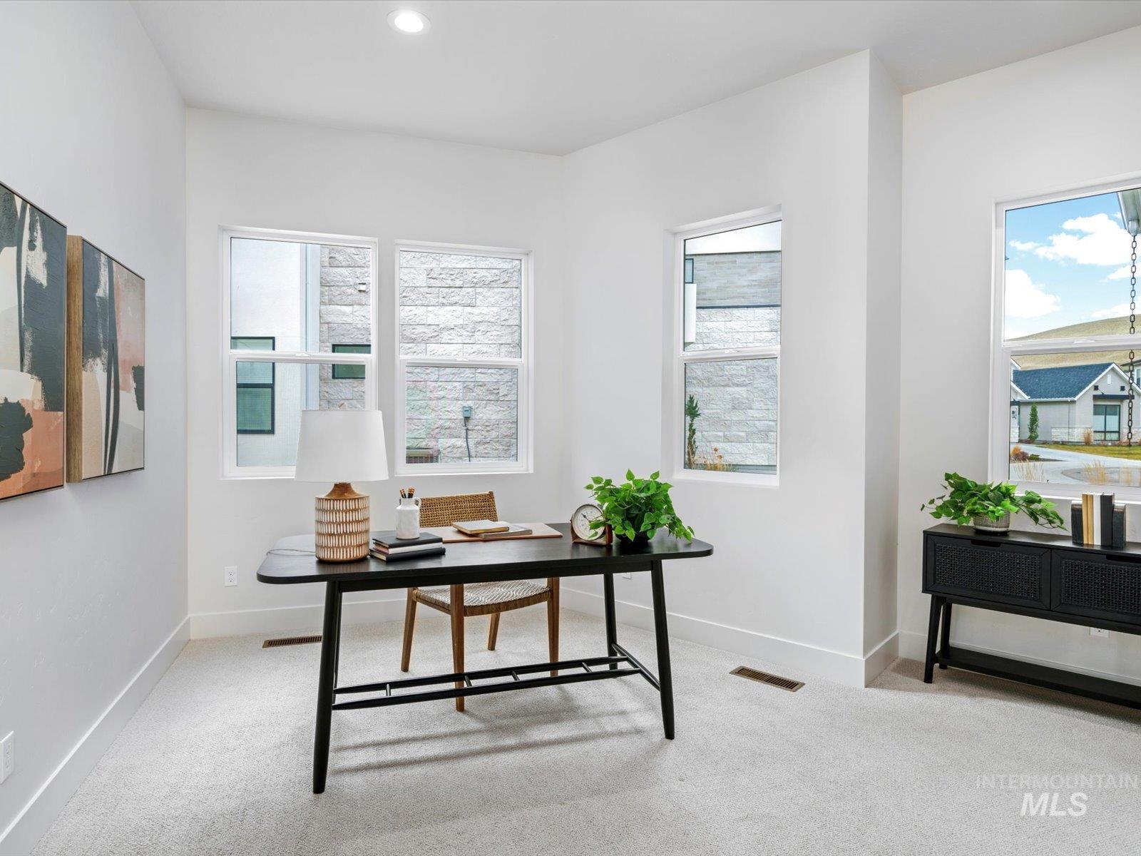 Office area with light carpet and recessed lighting