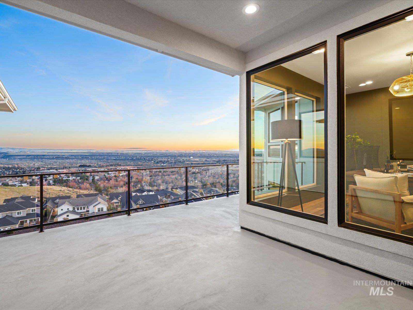 Balcony at dusk with a patio area and a residential view