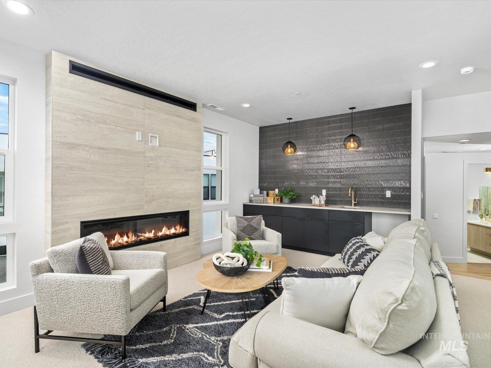 Living room featuring recessed lighting, a tile fireplace, and bar with sink