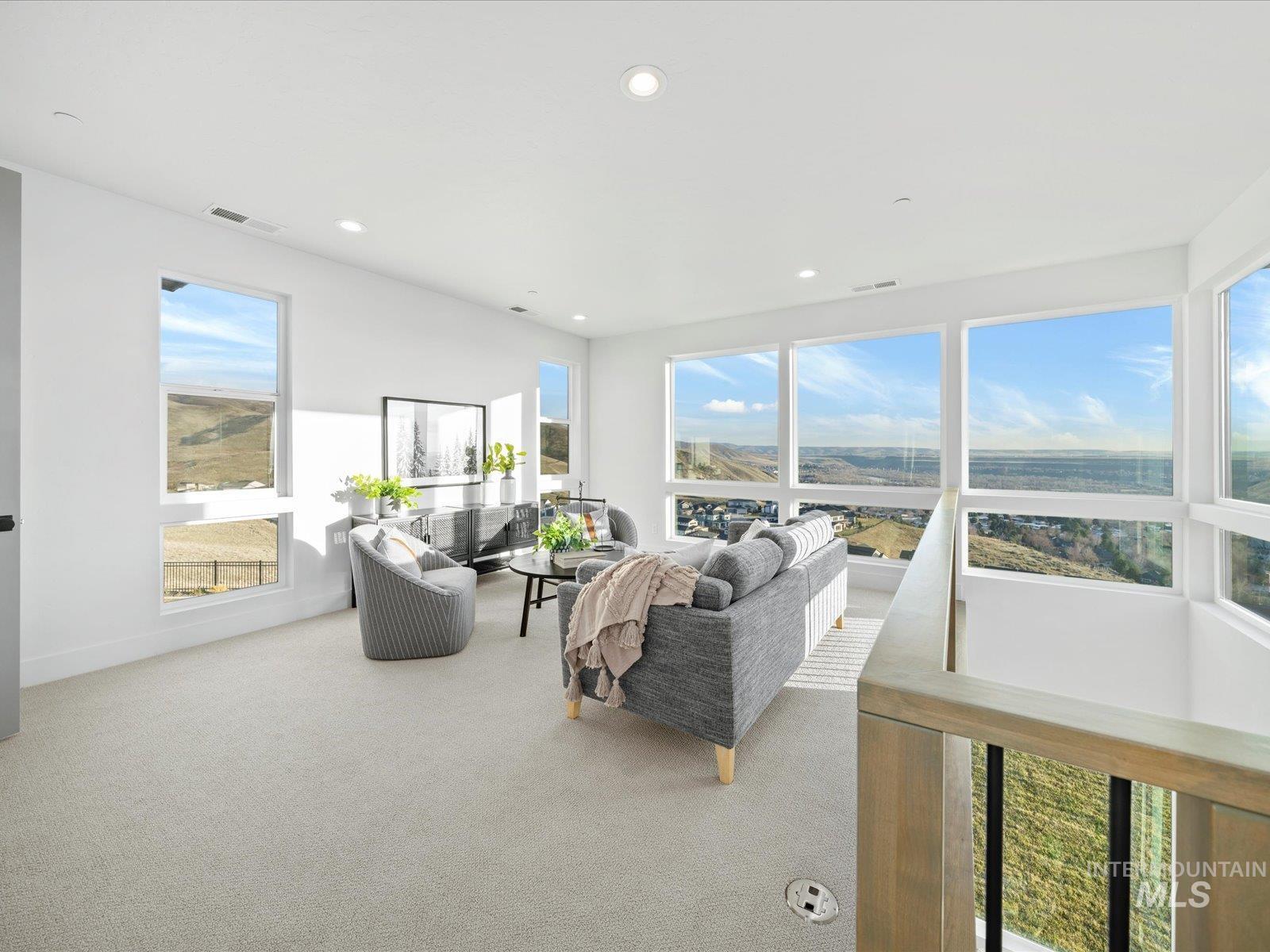Carpeted living area with plenty of natural light and recessed lighting