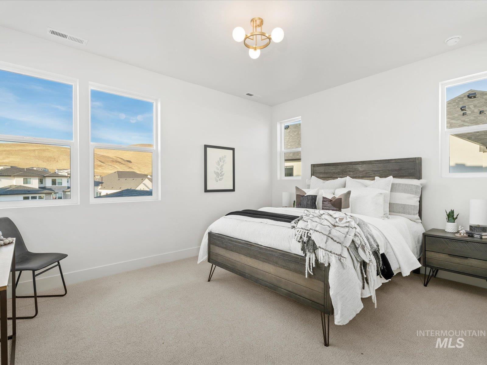 Bedroom featuring light colored carpet and a chandelier