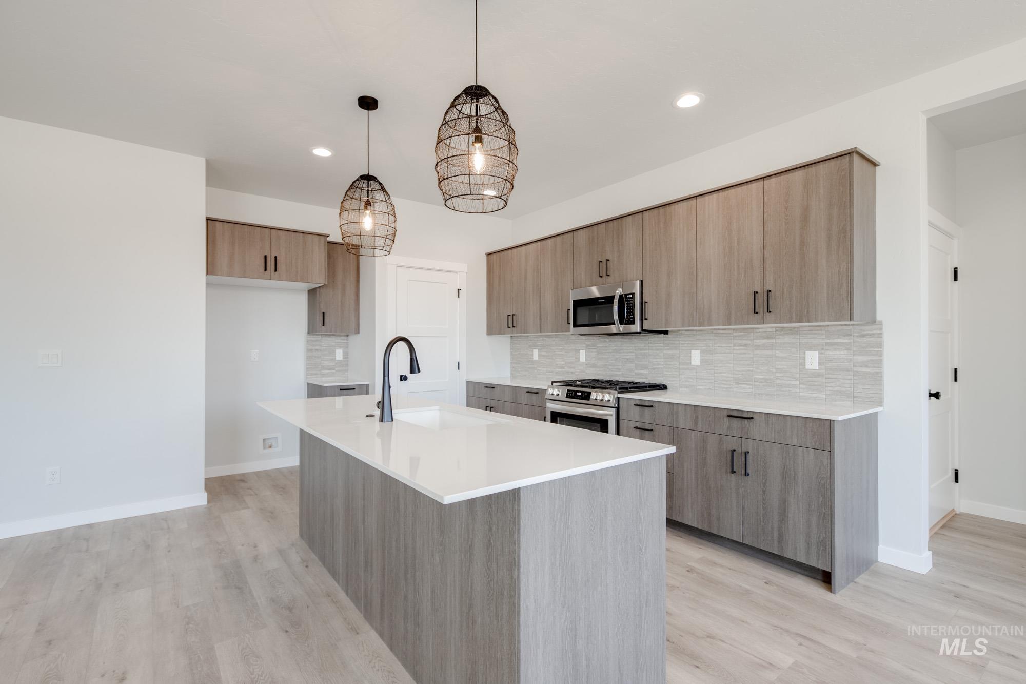 Kitchen featuring appliances with stainless steel finishes, modern cabinets, decorative backsplash, and recessed lighting
