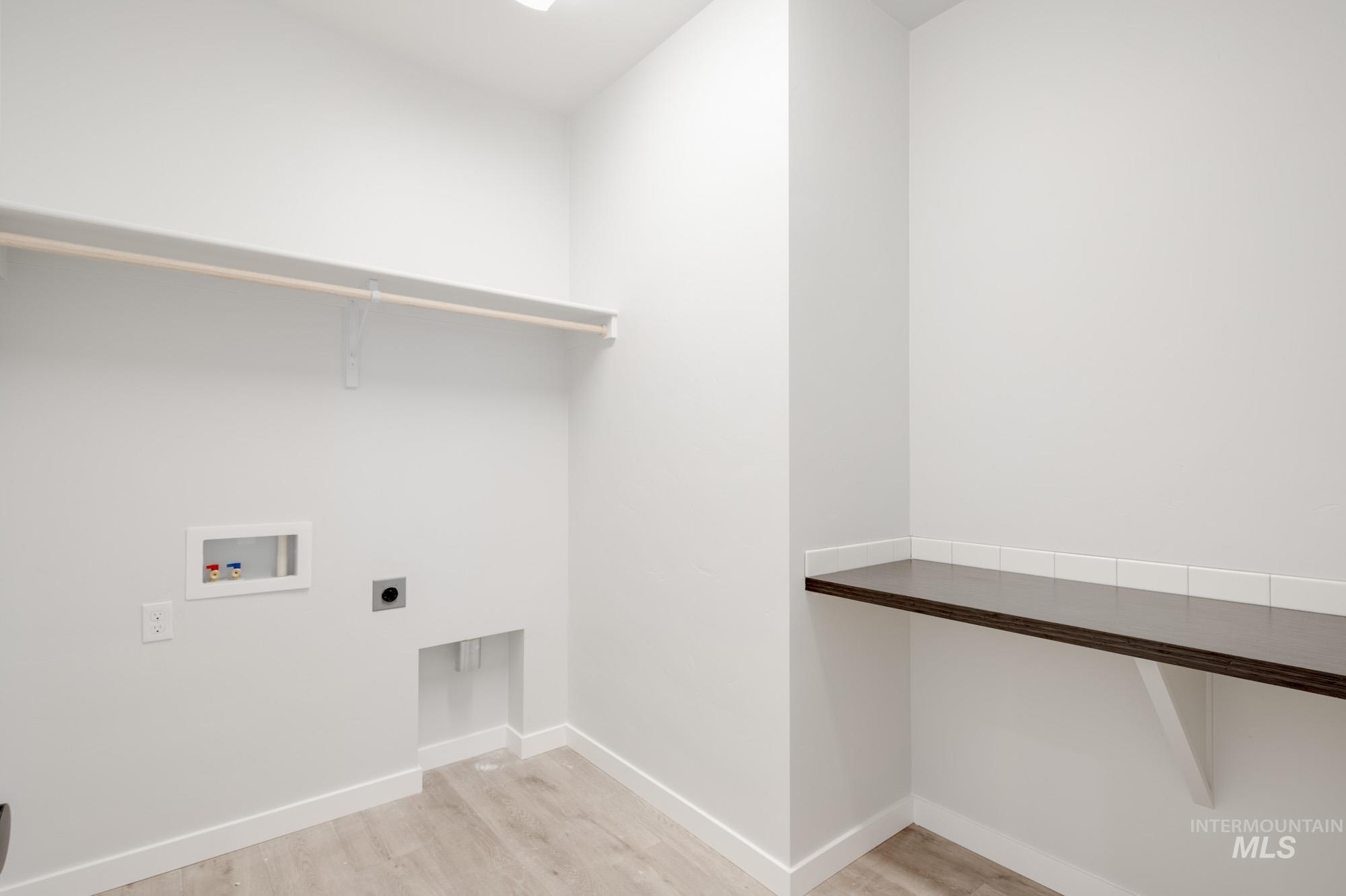 Washroom featuring electric dryer hookup, hookup for a washing machine, and light wood-style flooring