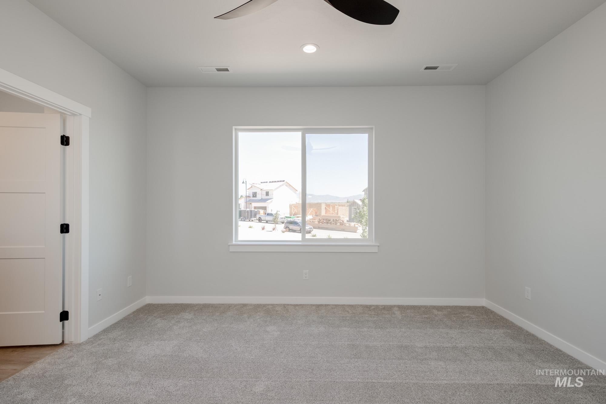 Spare room with a ceiling fan, light carpet, and recessed lighting