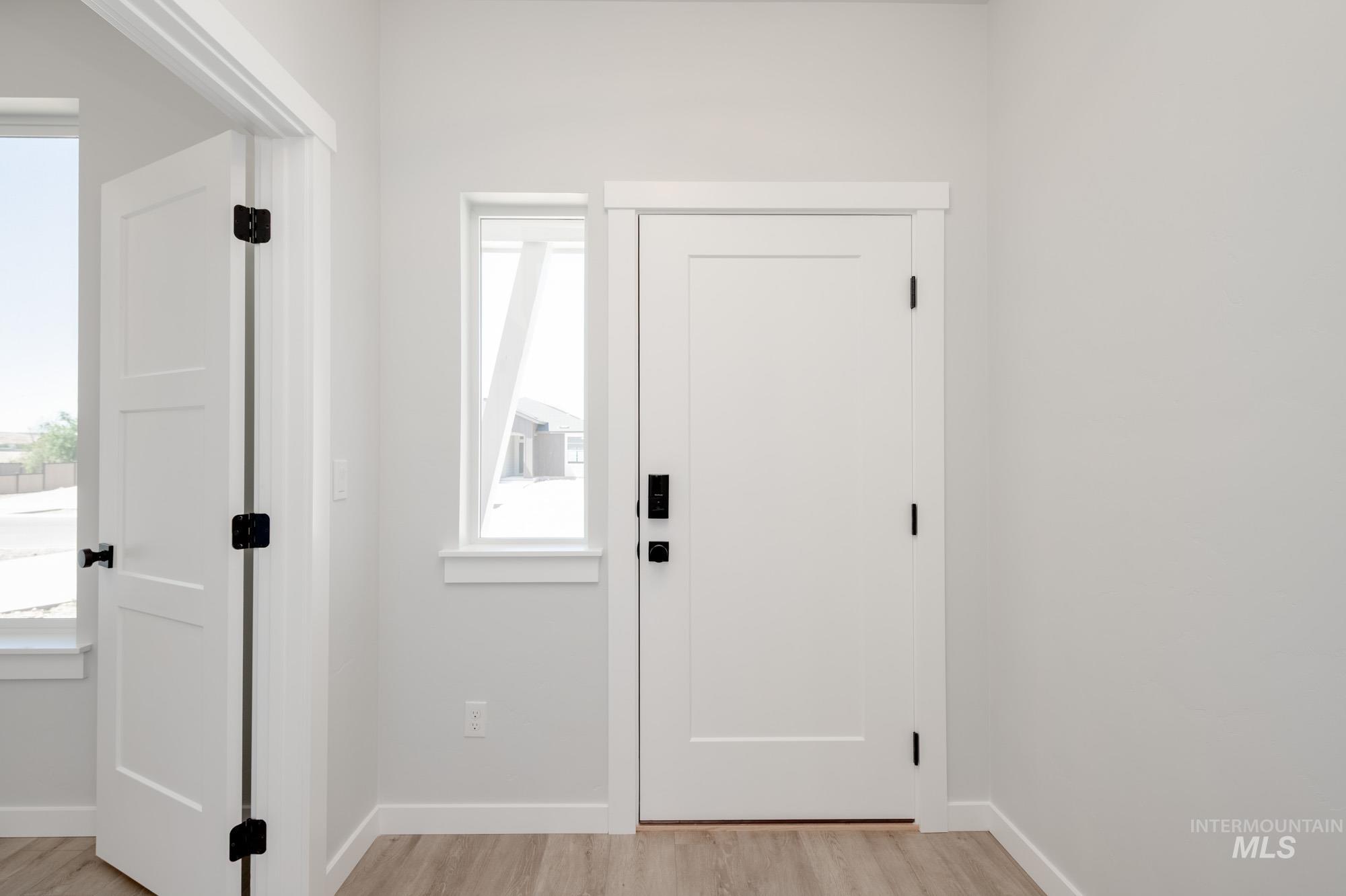 Foyer entrance featuring light wood-style floors and healthy amount of natural light