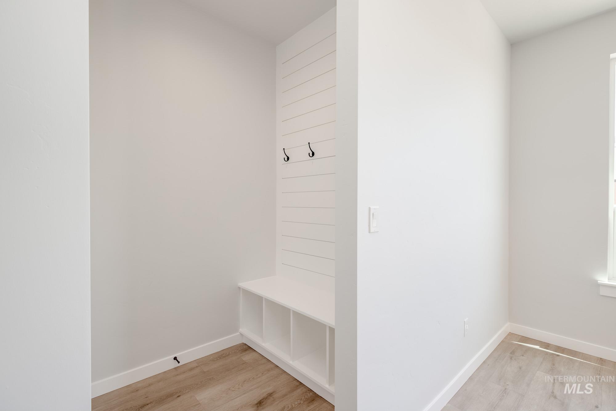 Mudroom with light wood finished floors and baseboards