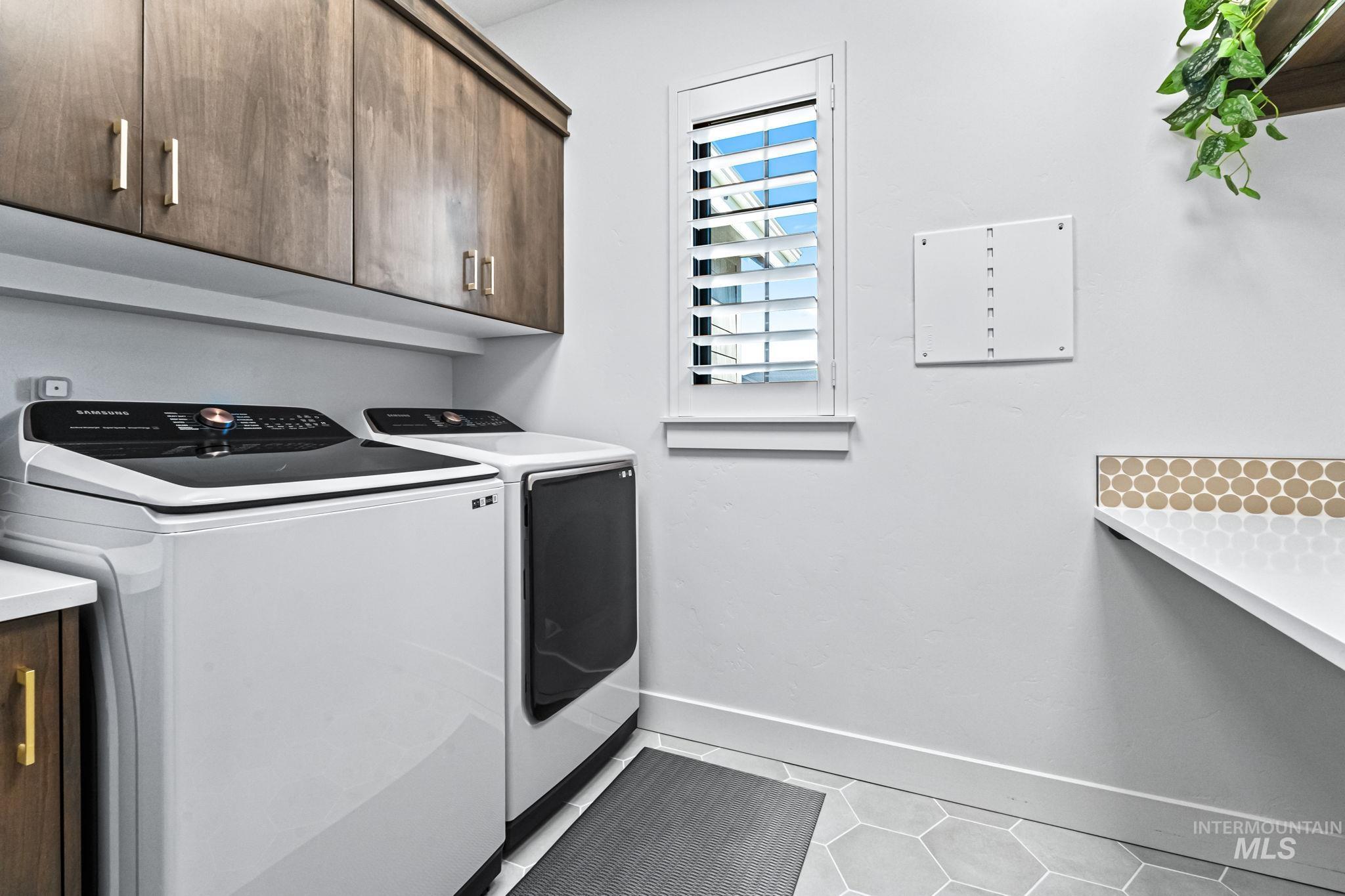 Washroom with cabinet space, separate washer and dryer, and tile patterned floors