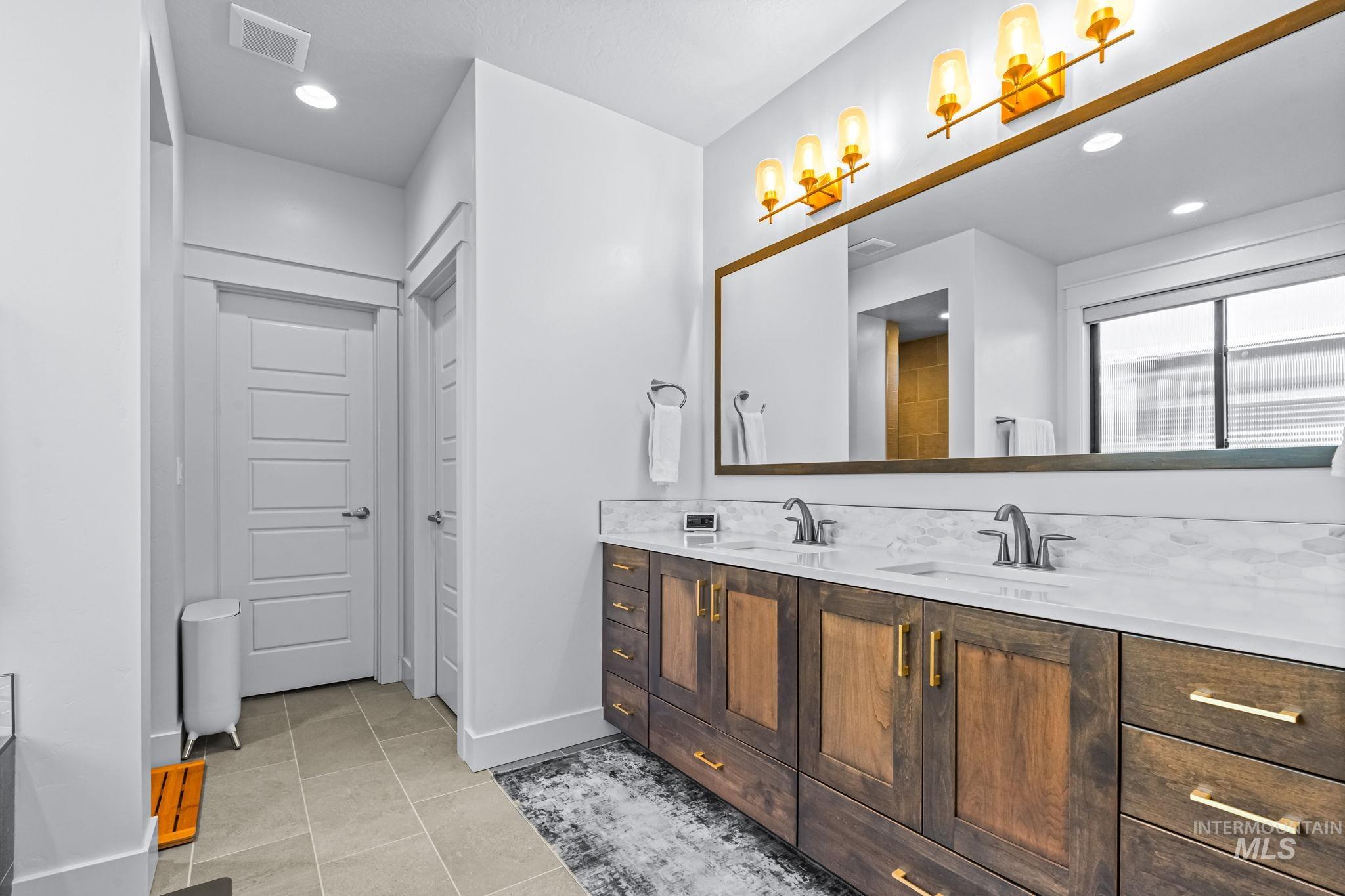 Full bathroom featuring double vanity, tile patterned floors, and recessed lighting