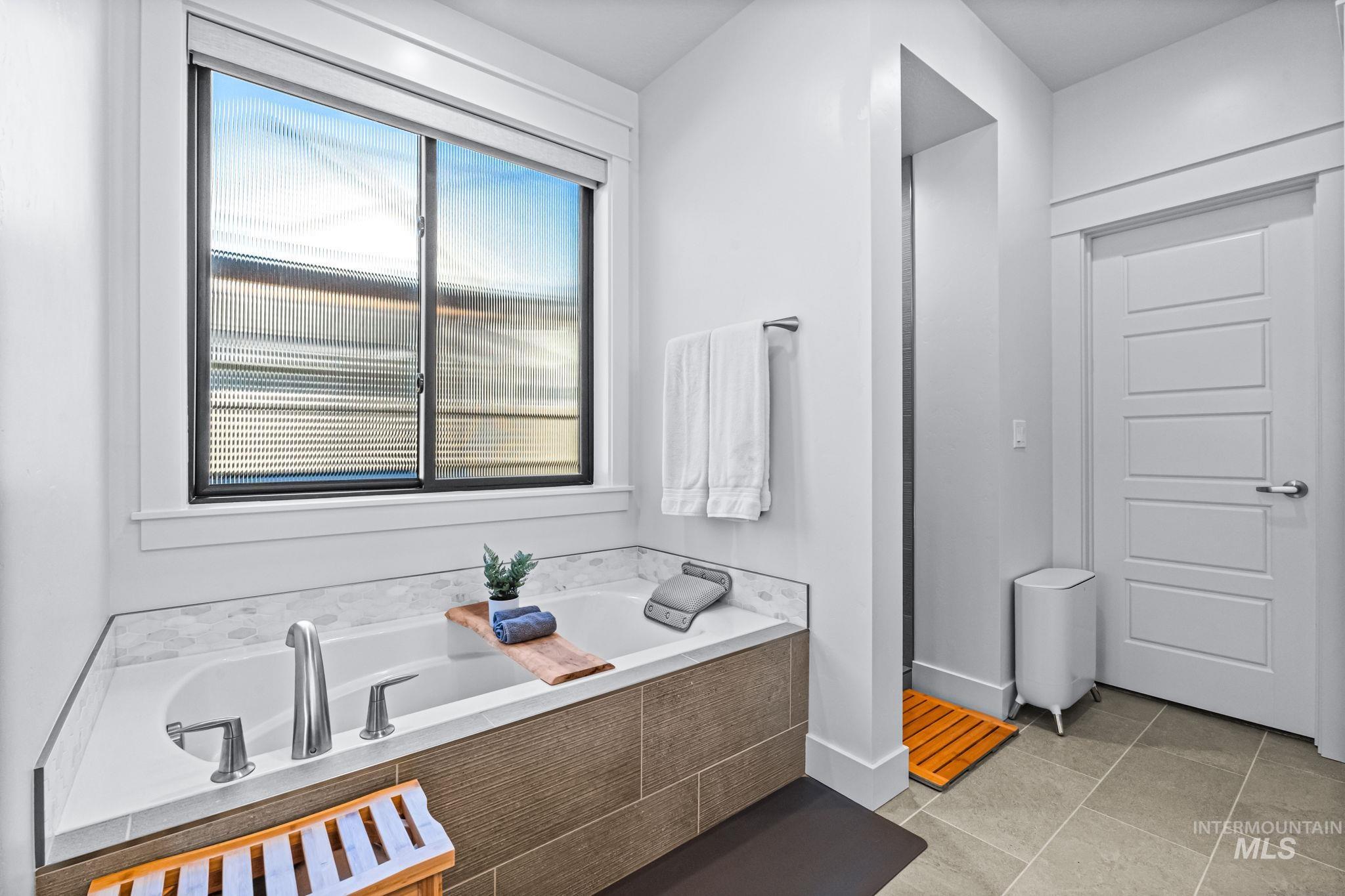Bathroom featuring a bath and tile patterned flooring