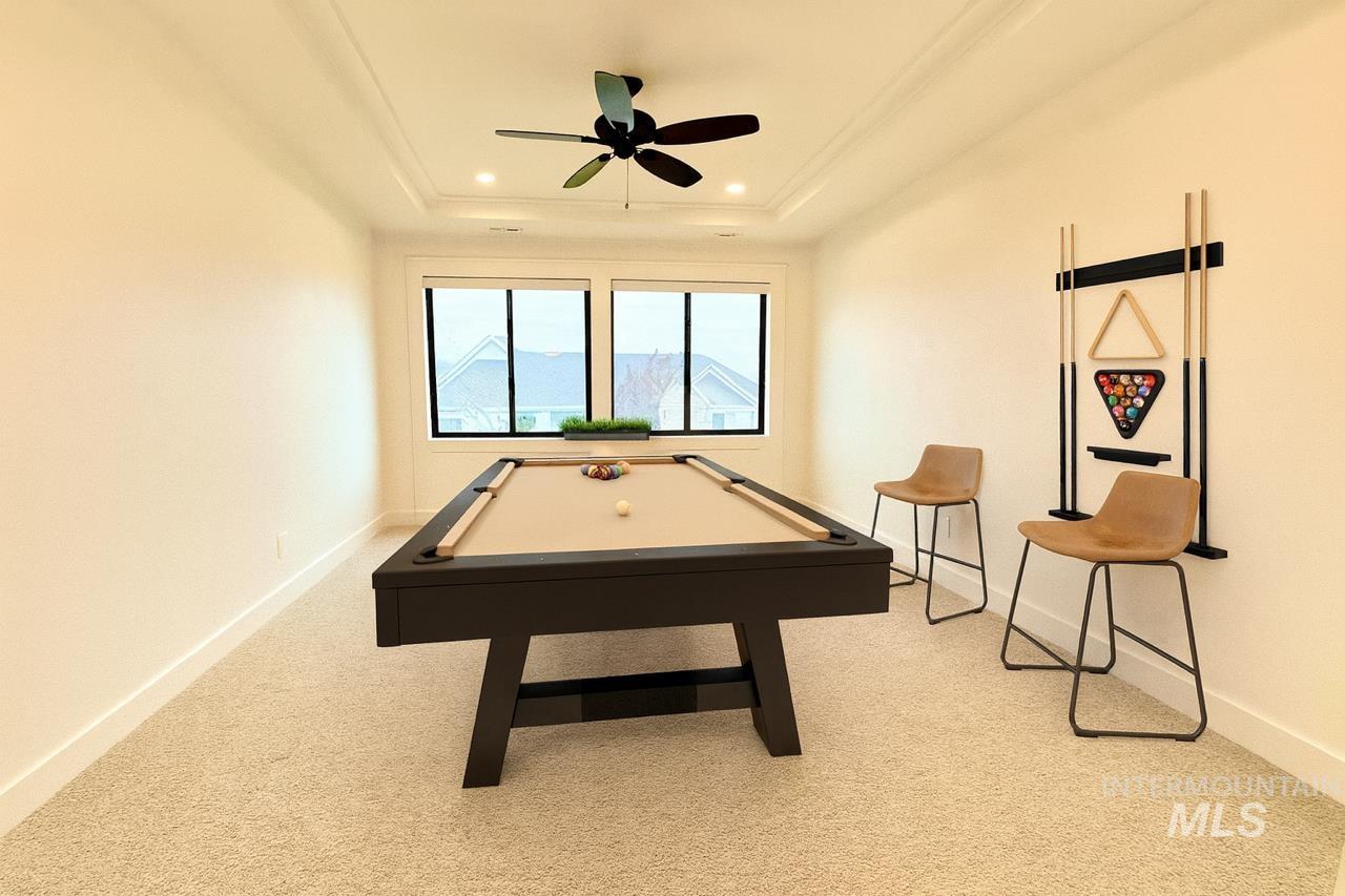 Rec room with billiards table, light colored carpet, a raised ceiling, recessed lighting, and a ceiling fan