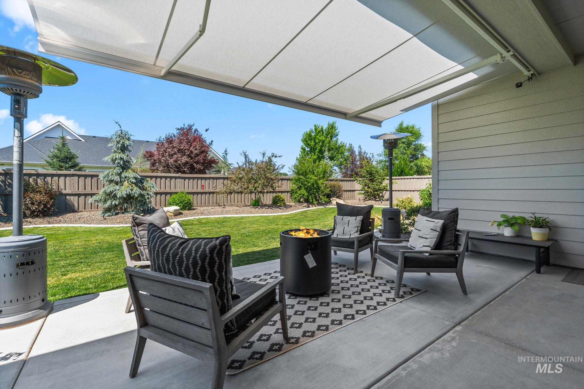 Fenced backyard with a patio area and a fire pit