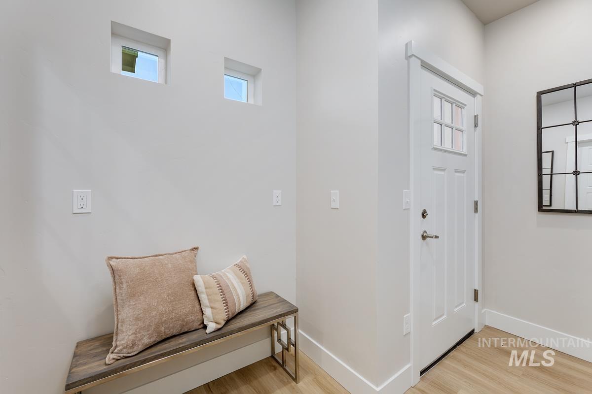 Foyer entrance with light wood-type flooring and baseboards