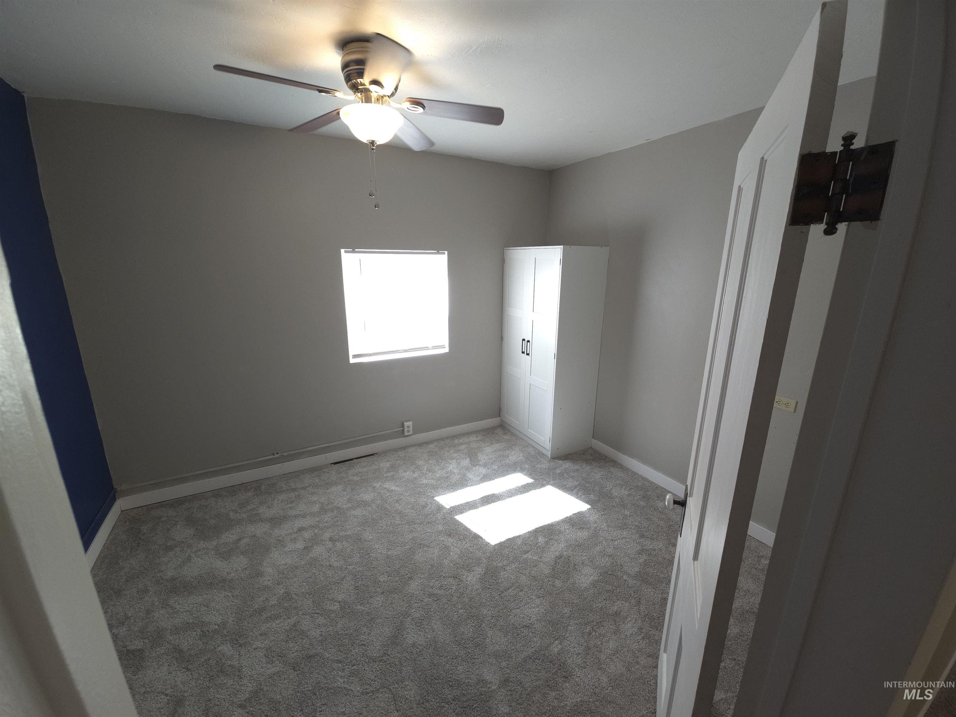 Unfurnished bedroom featuring light colored carpet and ceiling fan