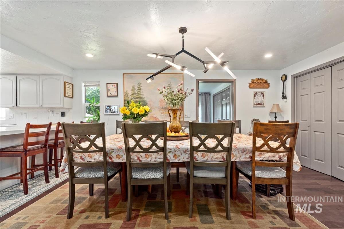 Dining area featuring dark wood-style floors, a textured ceiling, and recessed lighting