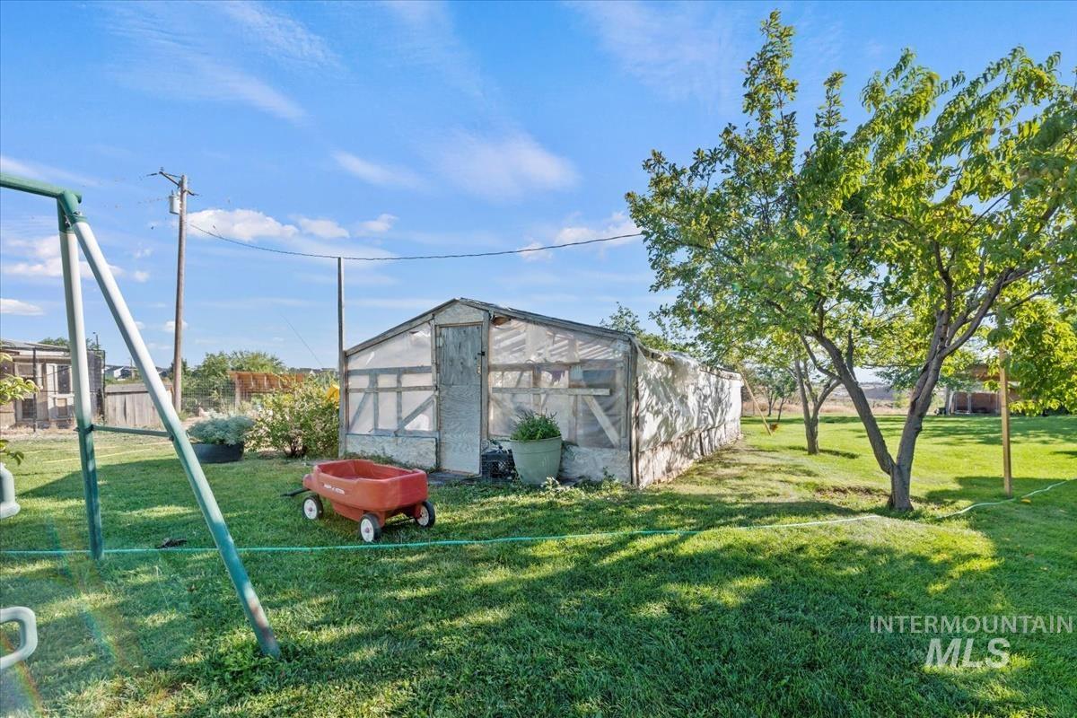 View of greenhouse featuring a lawn