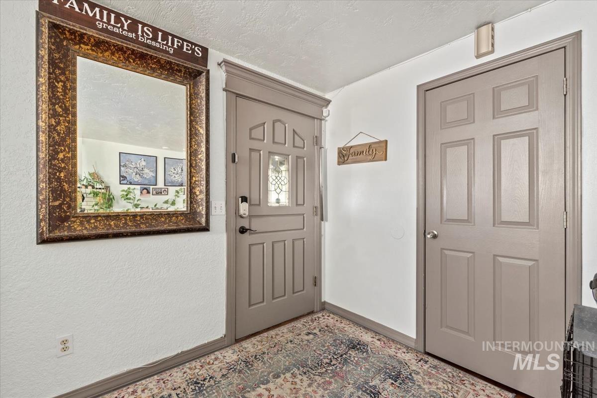 Entryway featuring baseboards and a textured ceiling