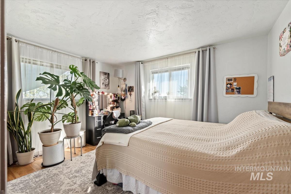 Bedroom featuring wood finished floors and a textured ceiling