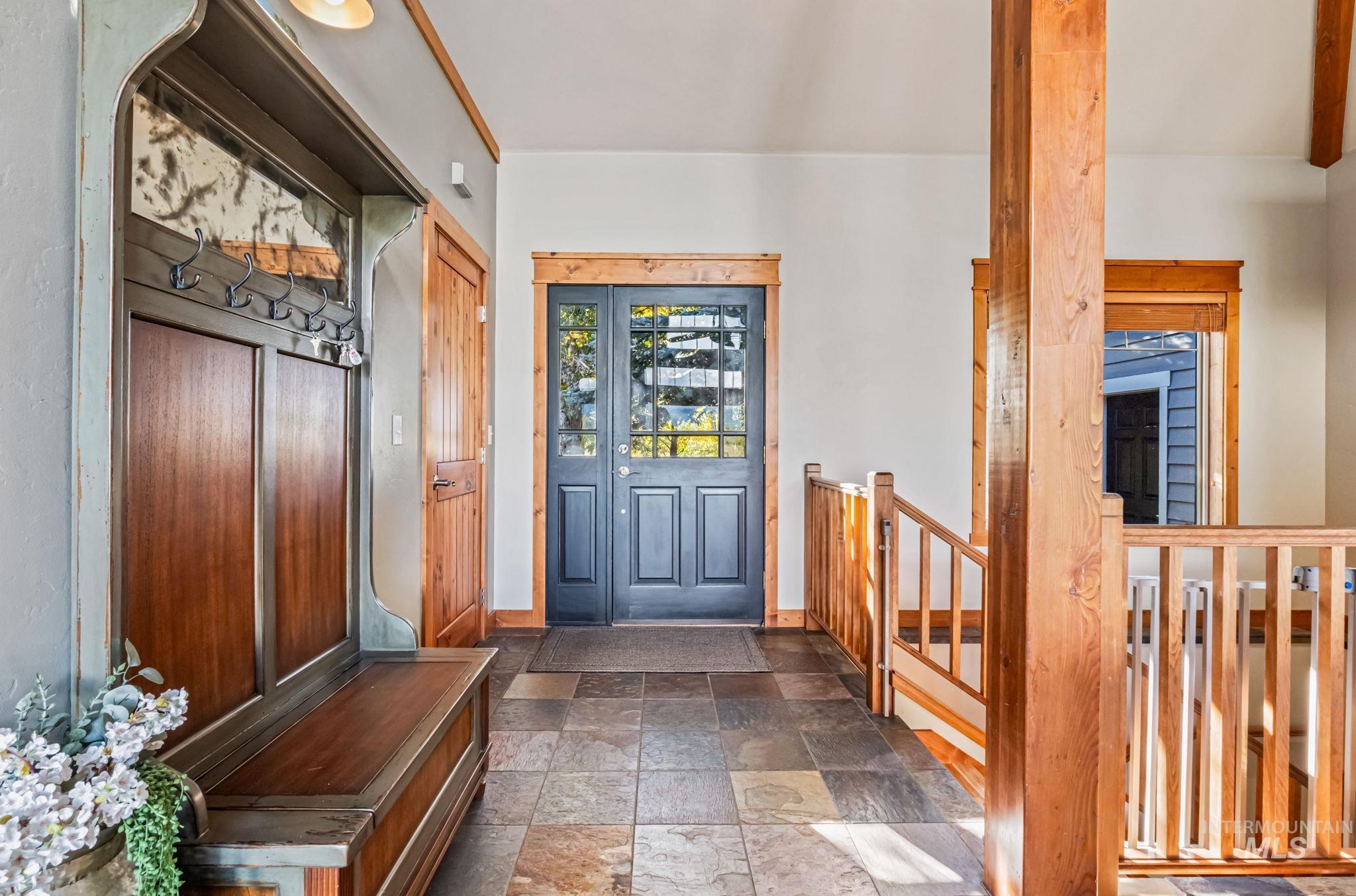 Entrance foyer featuring stone tile floors and baseboards