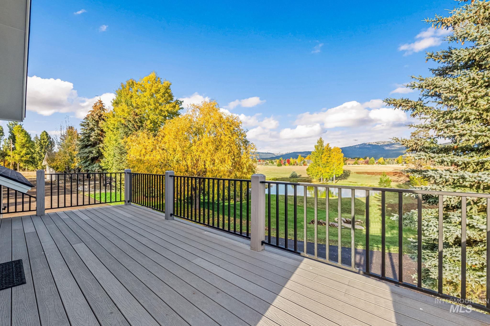 Wooden terrace featuring a water and mountain view