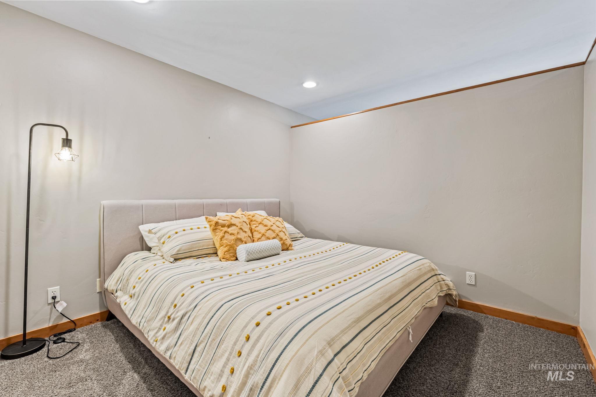 Carpeted bedroom with baseboards and recessed lighting