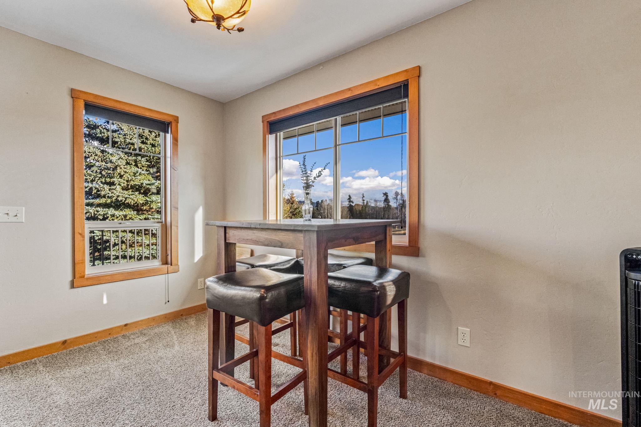 Dining space with healthy amount of natural light and light colored carpet