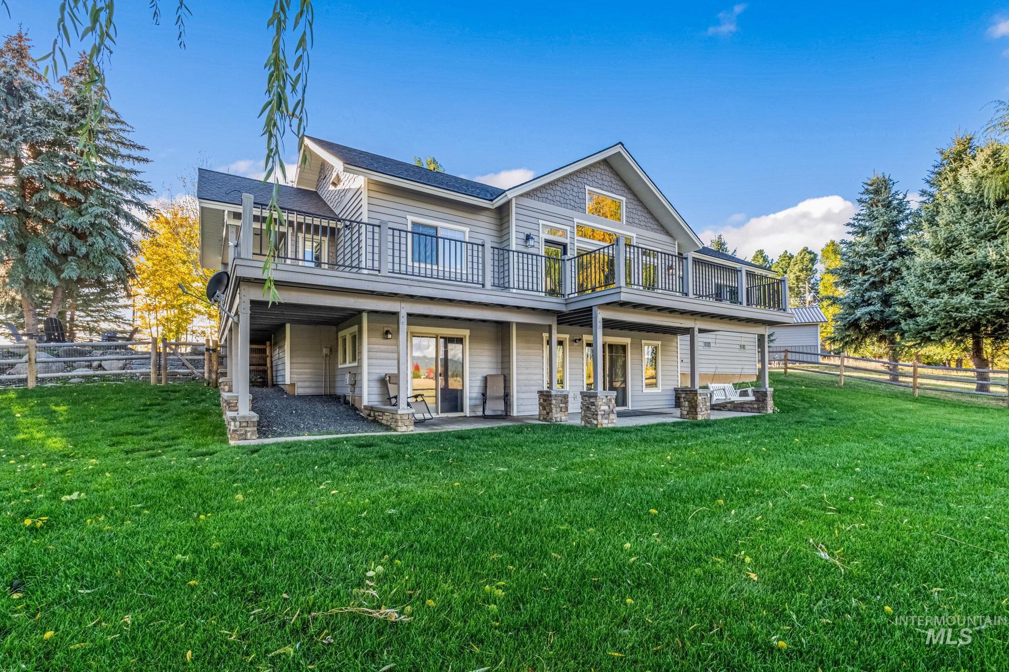 Back of house featuring a fenced backyard, a deck, and a patio