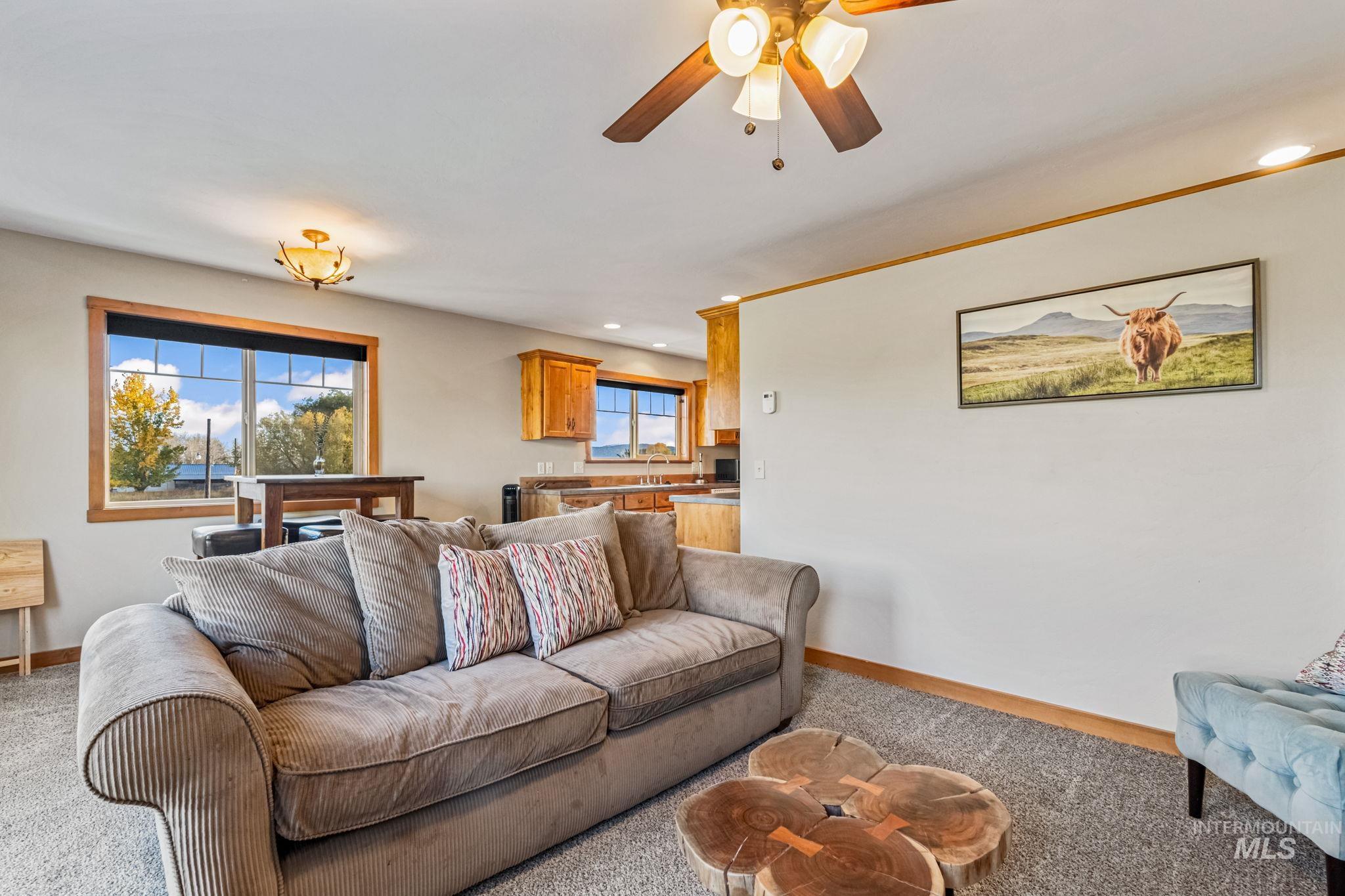 Carpeted living room featuring recessed lighting and a ceiling fan