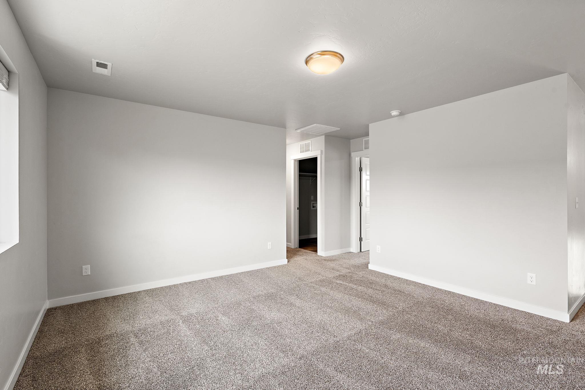 Carpeted empty room featuring baseboards