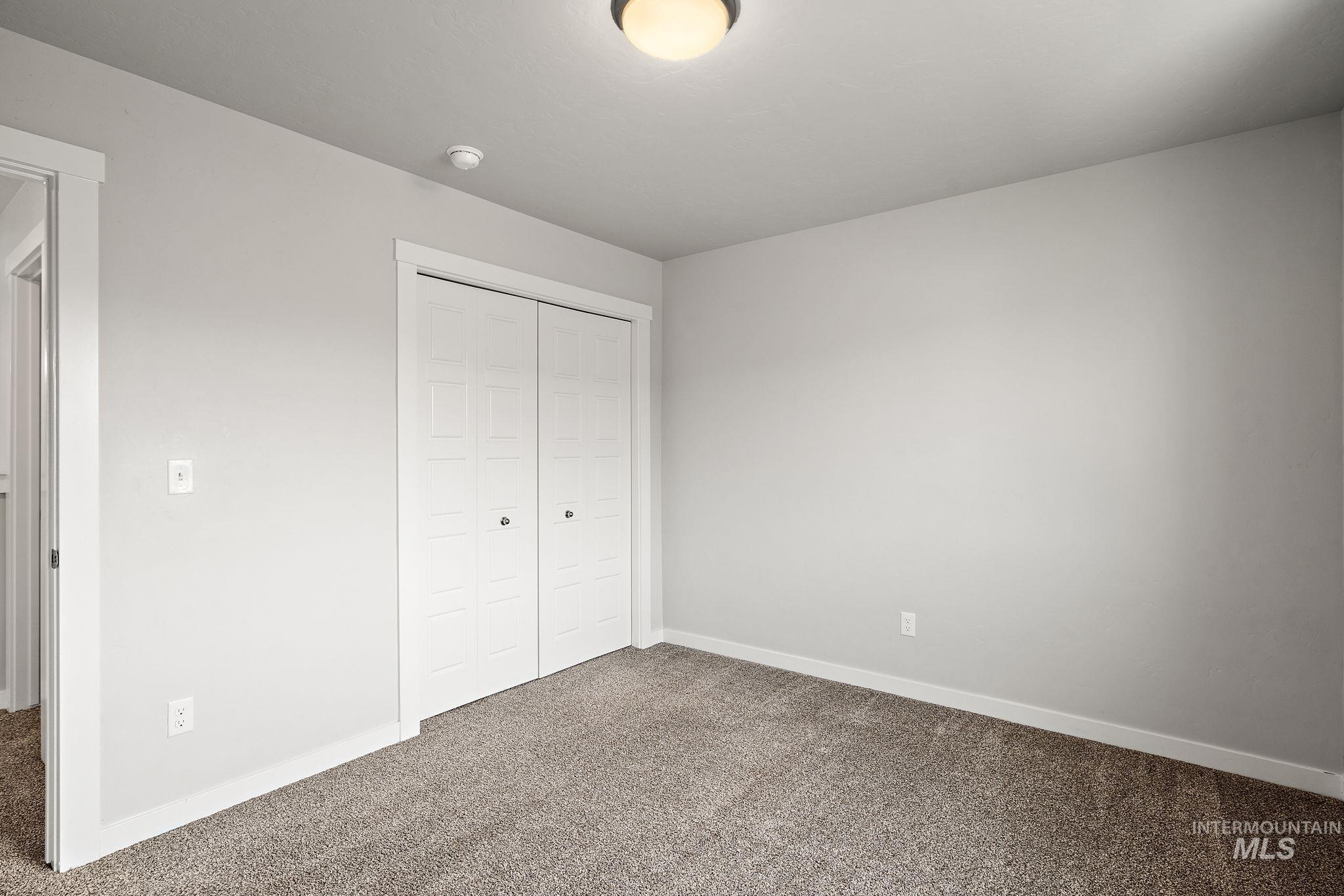 Unfurnished bedroom featuring carpet flooring and a closet