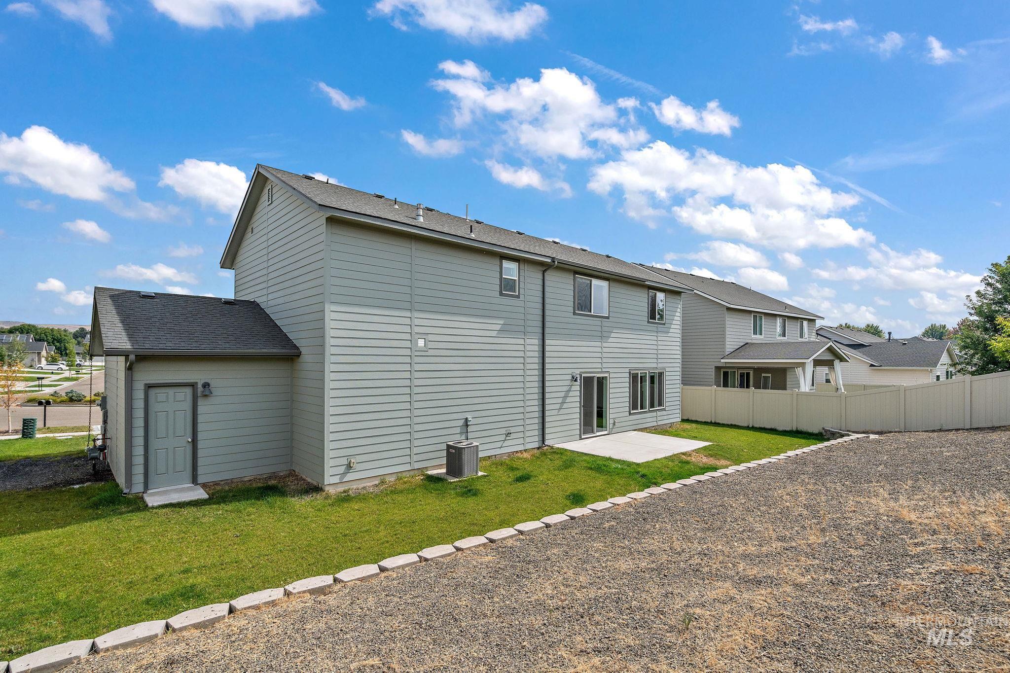 Rear view of property with a patio, a shingled roof, and a residential view