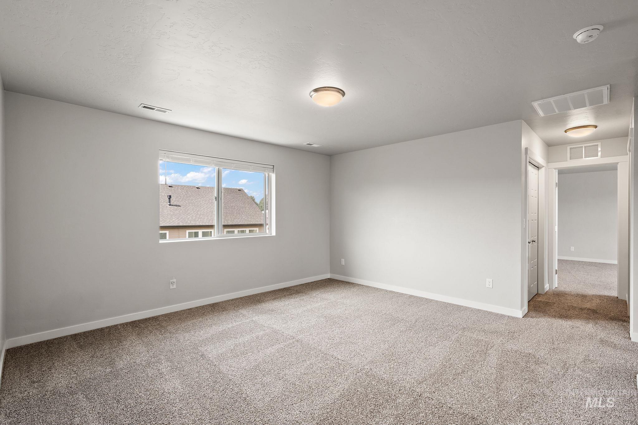 Spare room with light colored carpet and baseboards