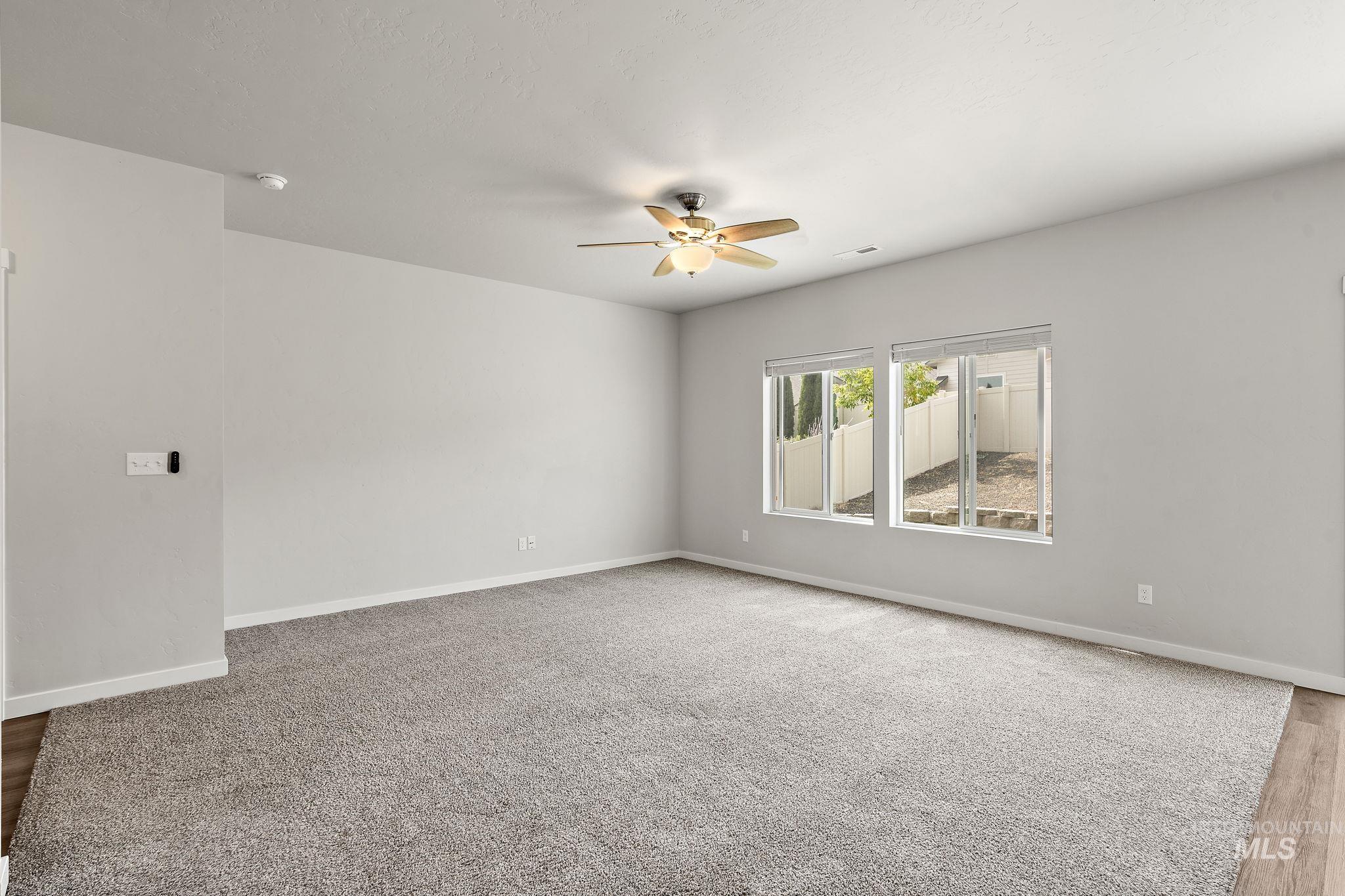 Unfurnished room featuring a ceiling fan and light carpet