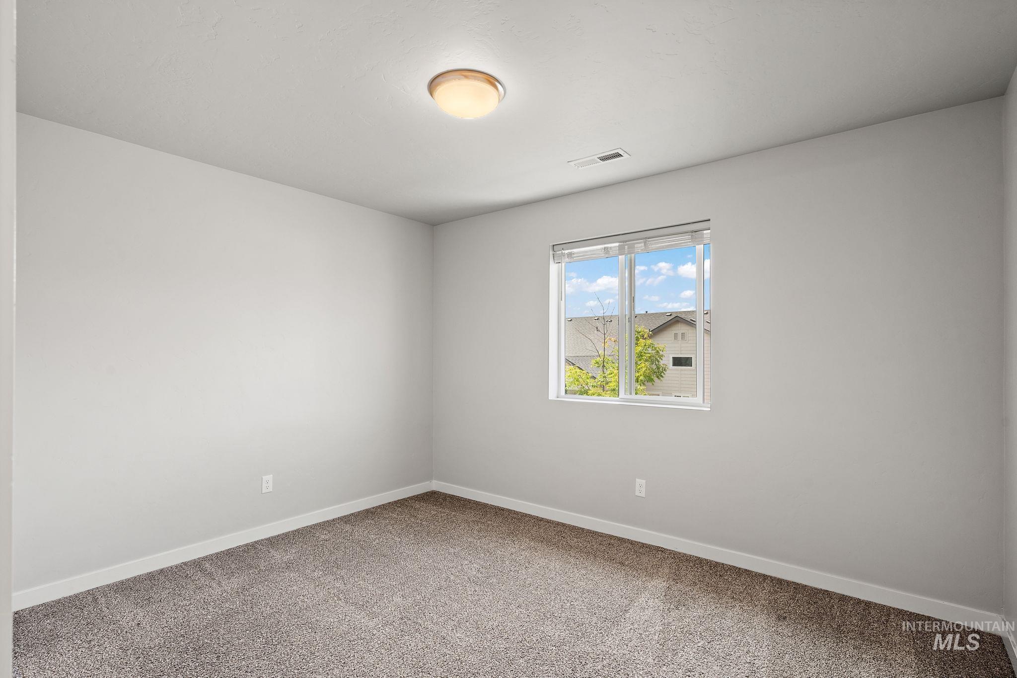 Carpeted empty room featuring baseboards