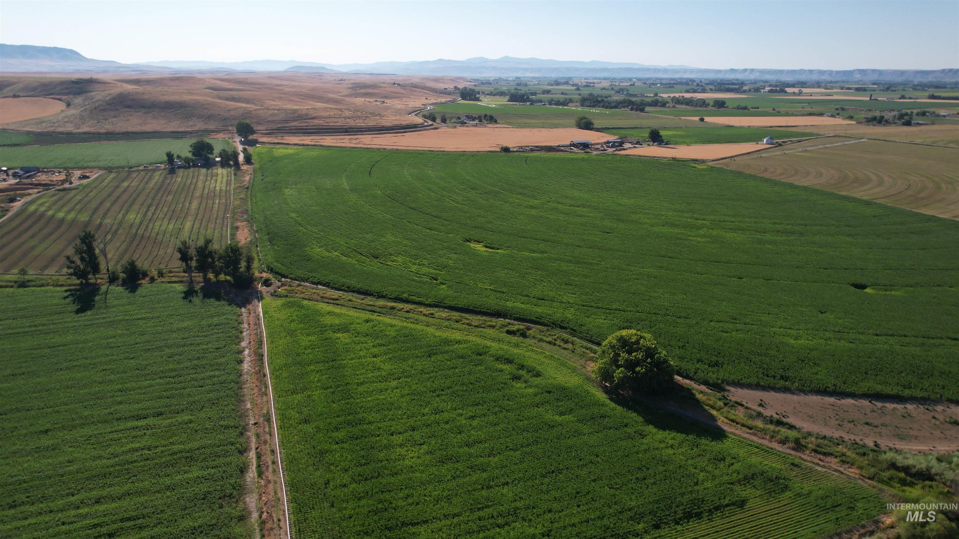 Aerial overview of property's location with rural landscape, farmland, and a mountainous background