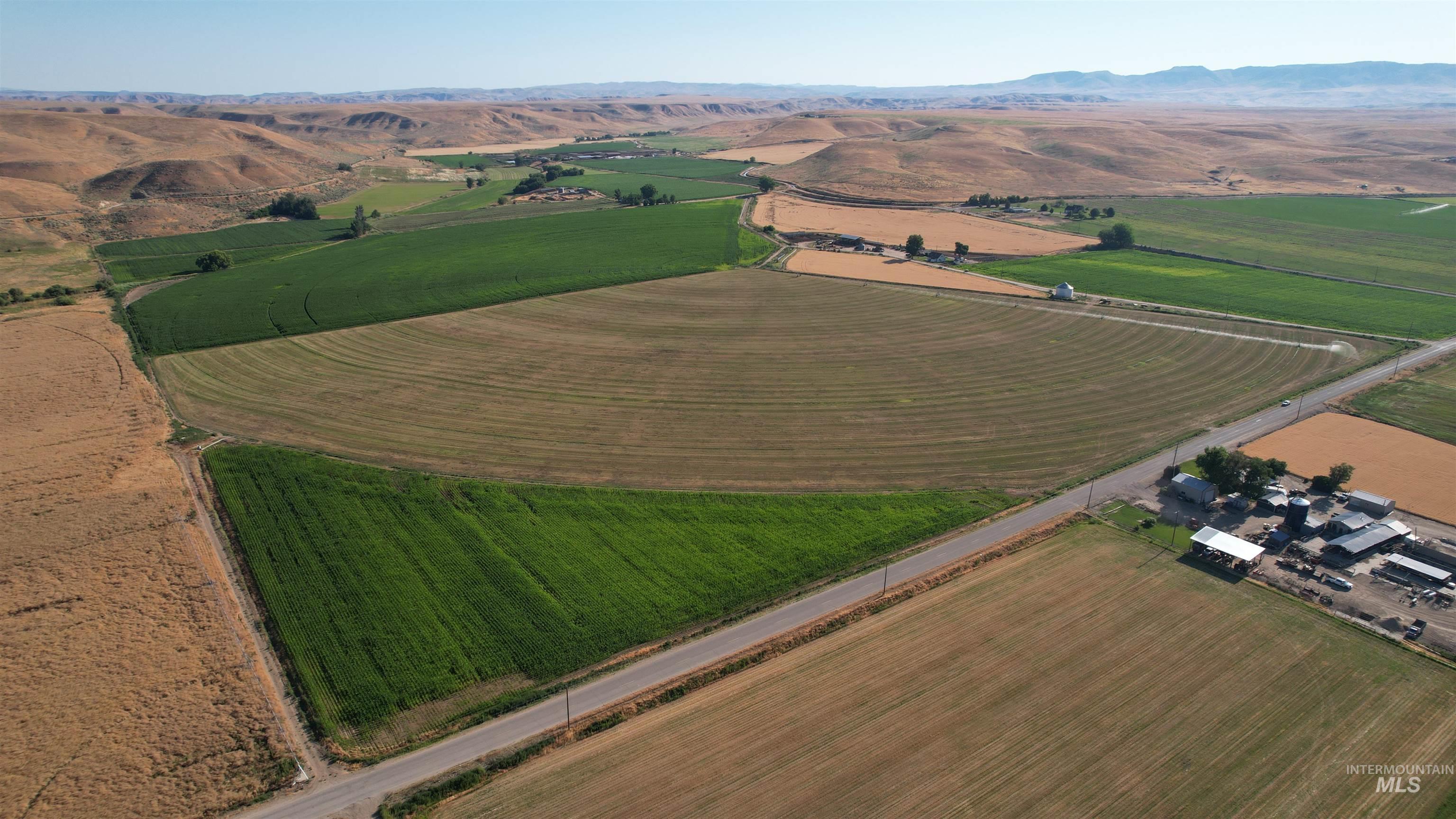 Aerial view of property's location featuring rural landscape, extensive farmland, and a mountainous background