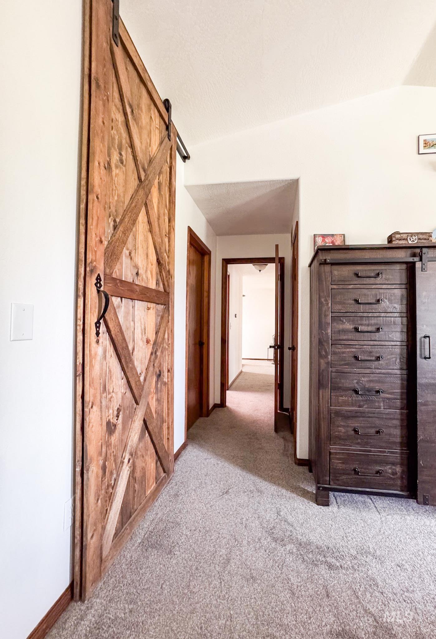Hall featuring carpet floors and a barn door