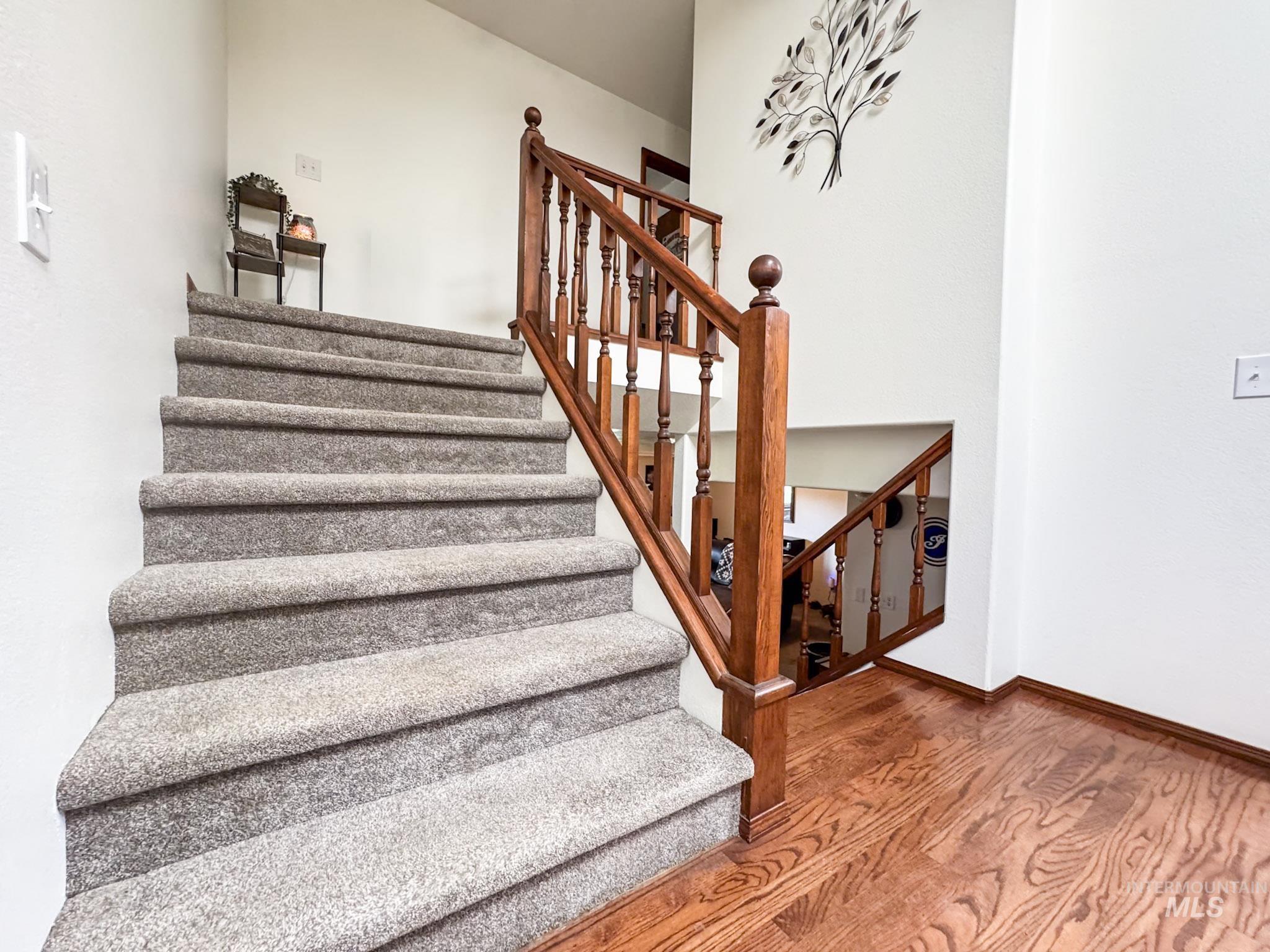Stairs featuring wood finished floors and baseboards